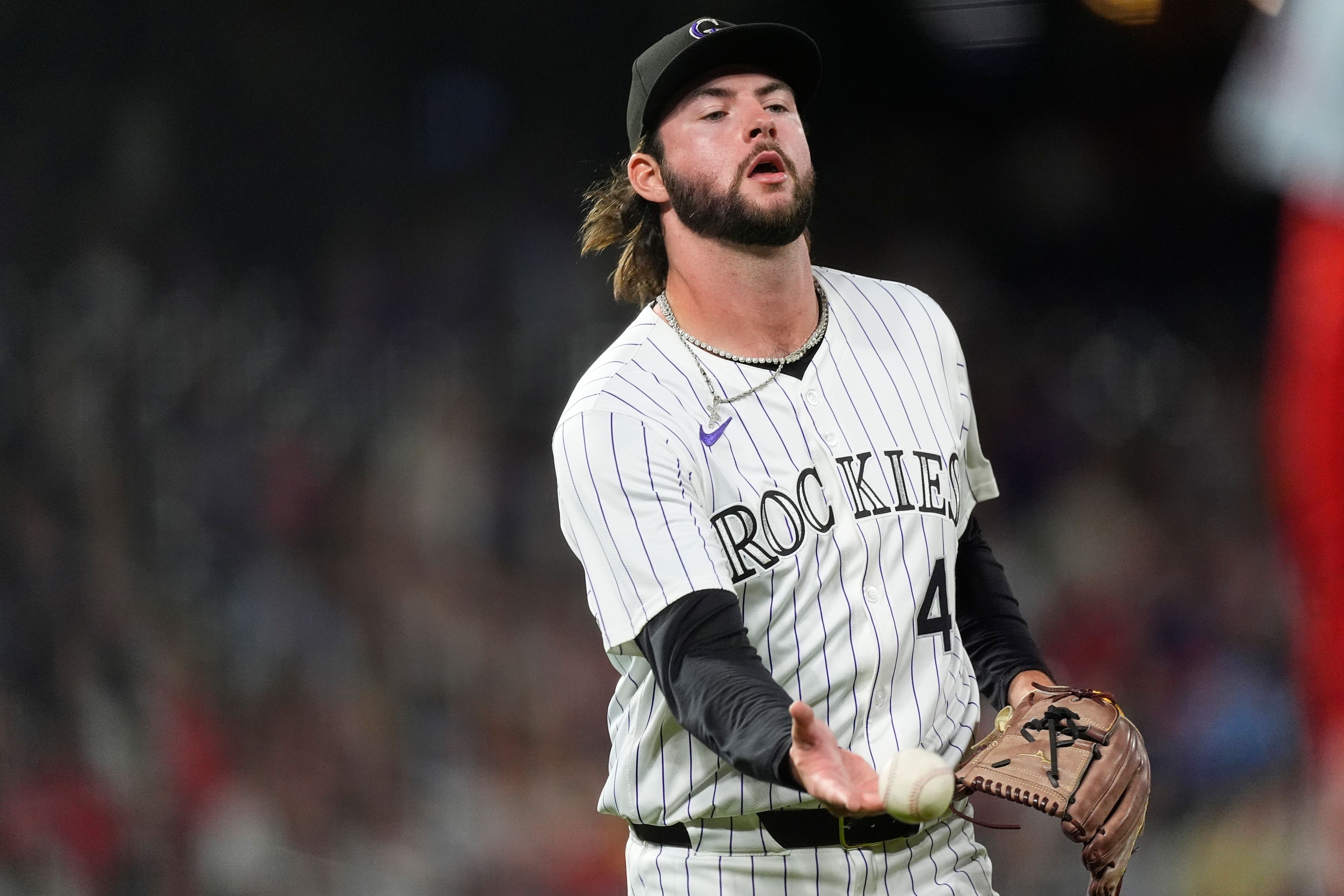 Colorado Rockies relief pitcher Jeff Criswell tosses the ball to first base to put out St. Louis Cardinals' Michael Siani to end the top of the sixth inning of a baseball game Wednesday, Sept. 25, 2024, in Denver. (AP Photo/David Zalubowski)