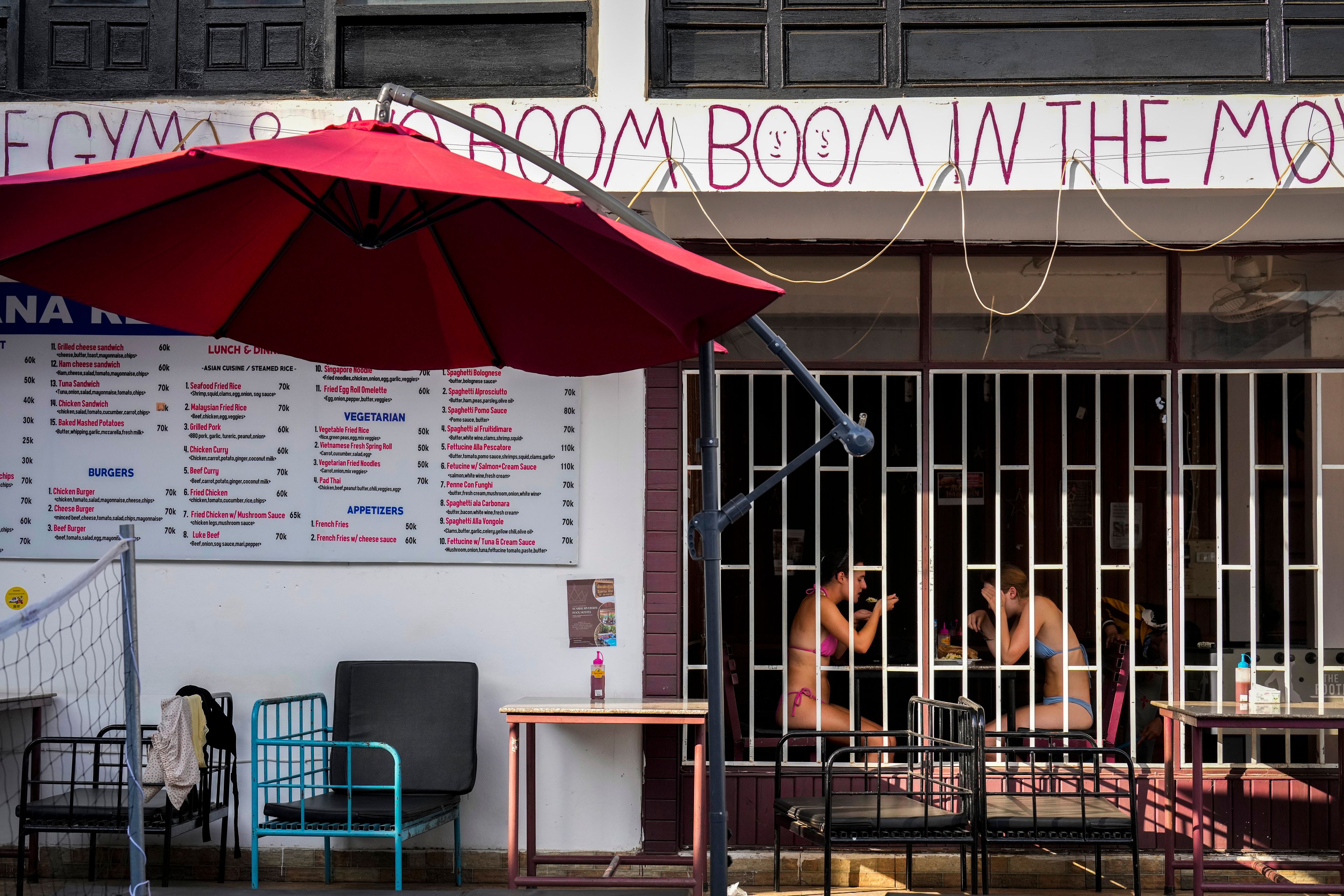 Tourists eat food at Nana Backpack hostel in Vang Vieng, Laos, Tuesday, Nov. 19, 2024. (AP Photo/Anupam Nath)