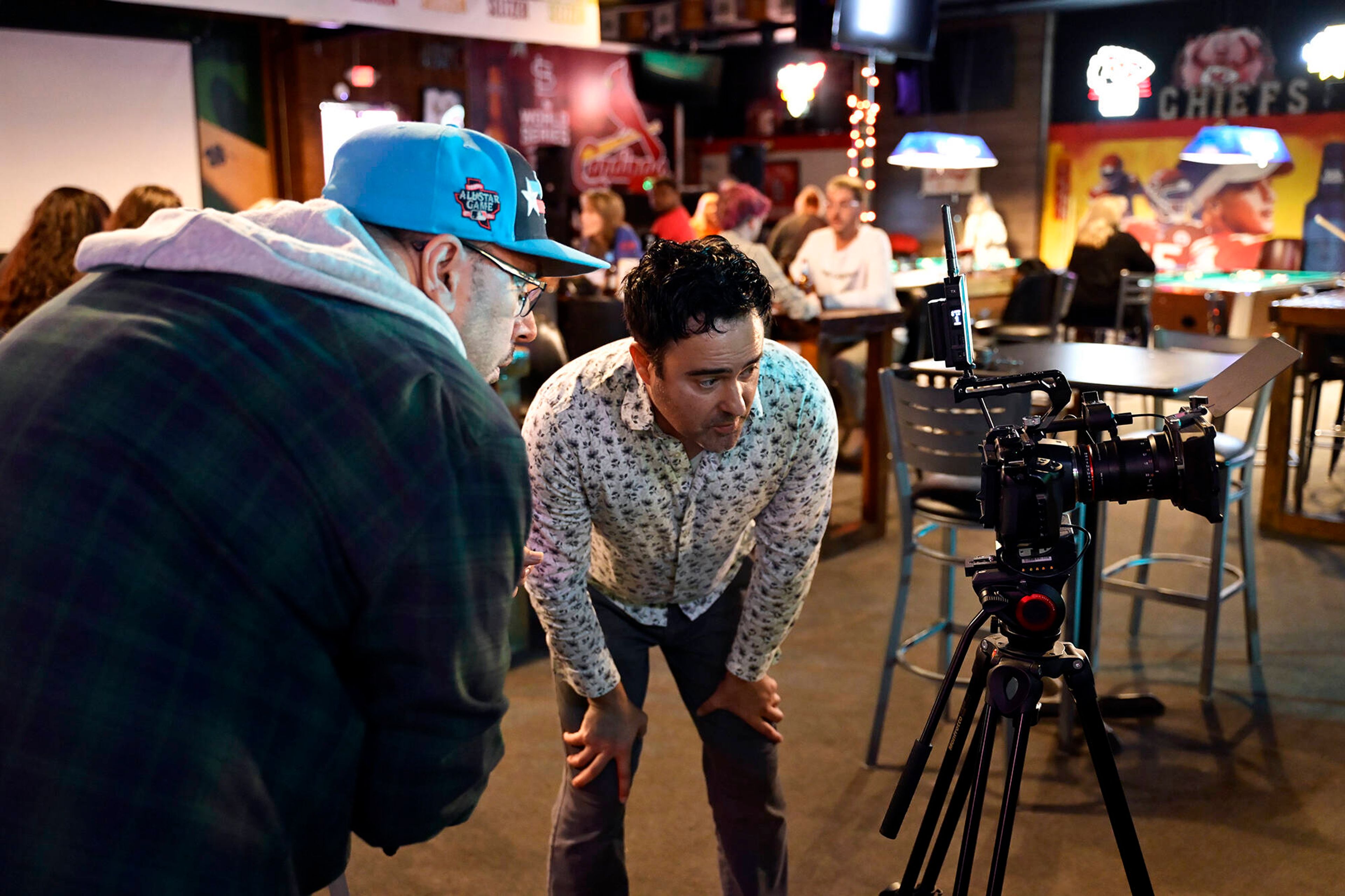 Michael Hibler and his production assistant view how a shot is lined up and how the lighting is set before filming Sunday morning, Nov.  10, at Haffy’s Sports Bar and Grill in Poplar Bluff.