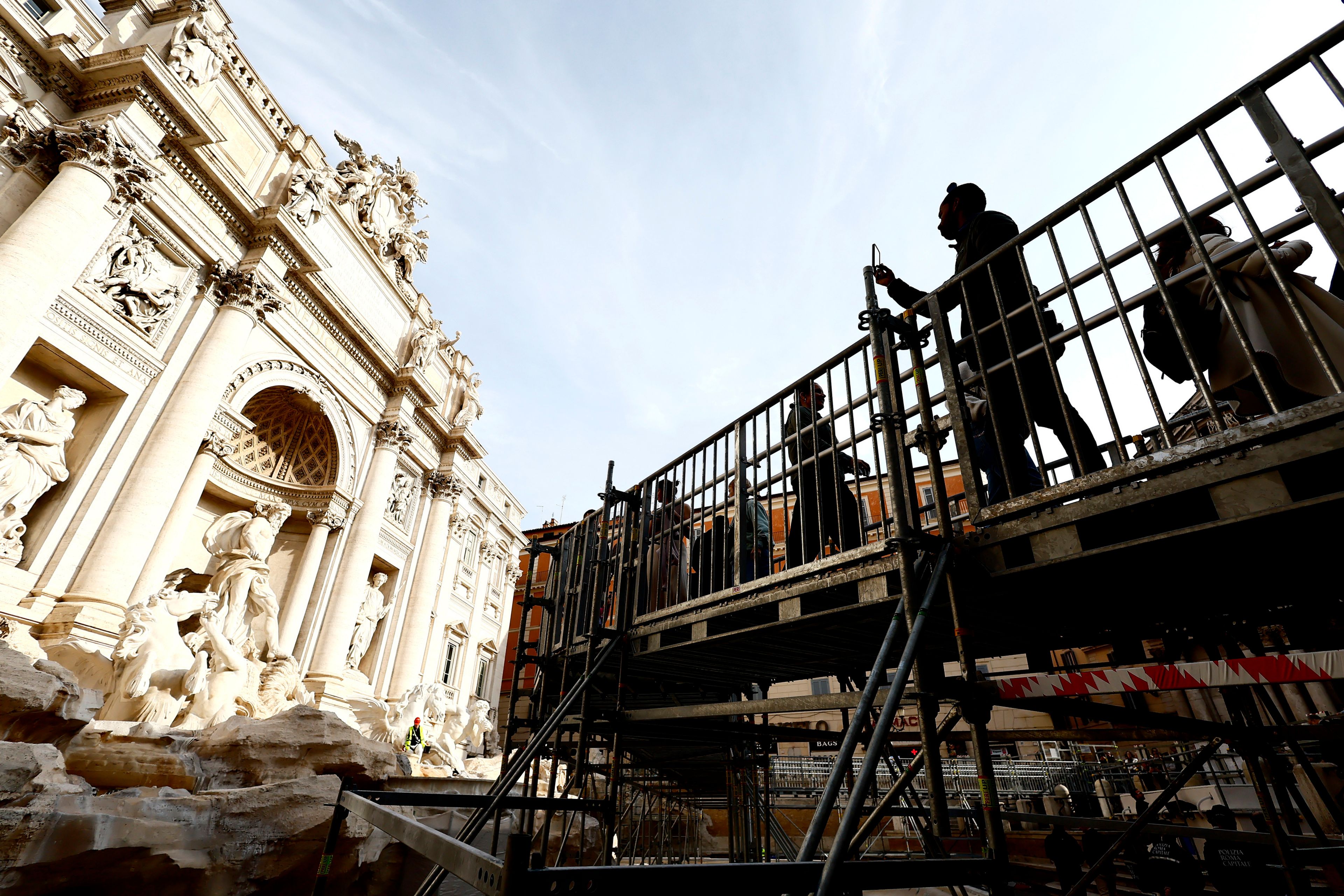 People walk along an elevated walkway that gives limited access to the Trevi Fountain monument during maintenance work in Rome, Saturday, Nov. 9, 2024. (Cecilia Fabiano/LaPresse via AP)