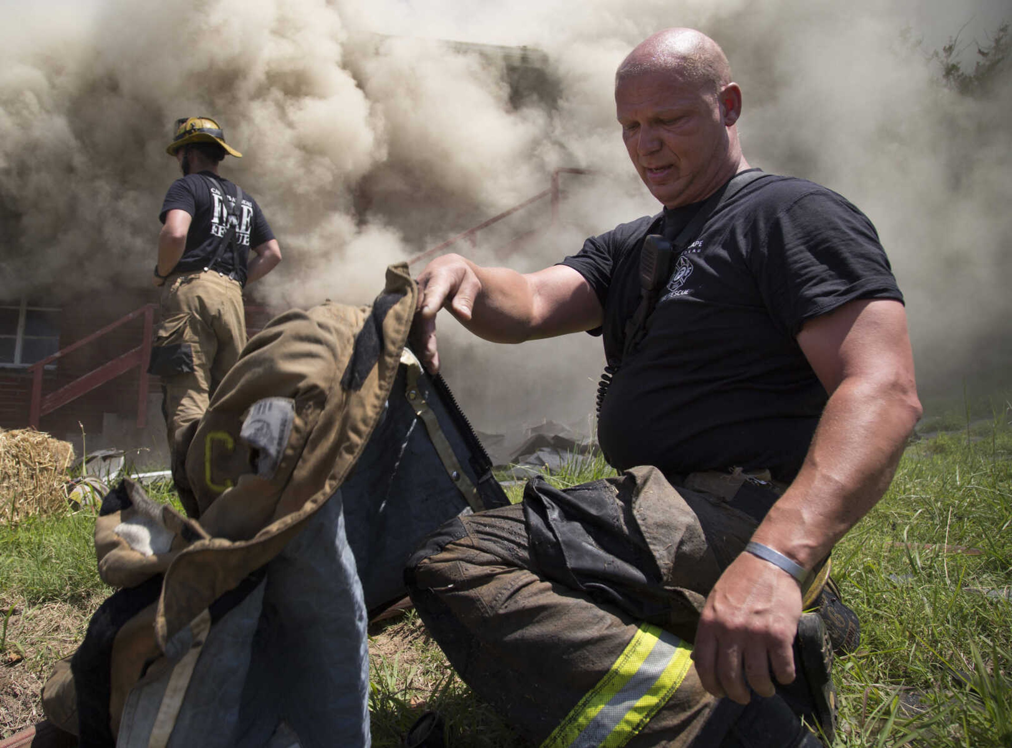 Cape Girardeau firefighter Brad Martin removes his fire jacket during Saturday's live-burn fire training June 10, 2017 near Route K in Cape Girardeau.