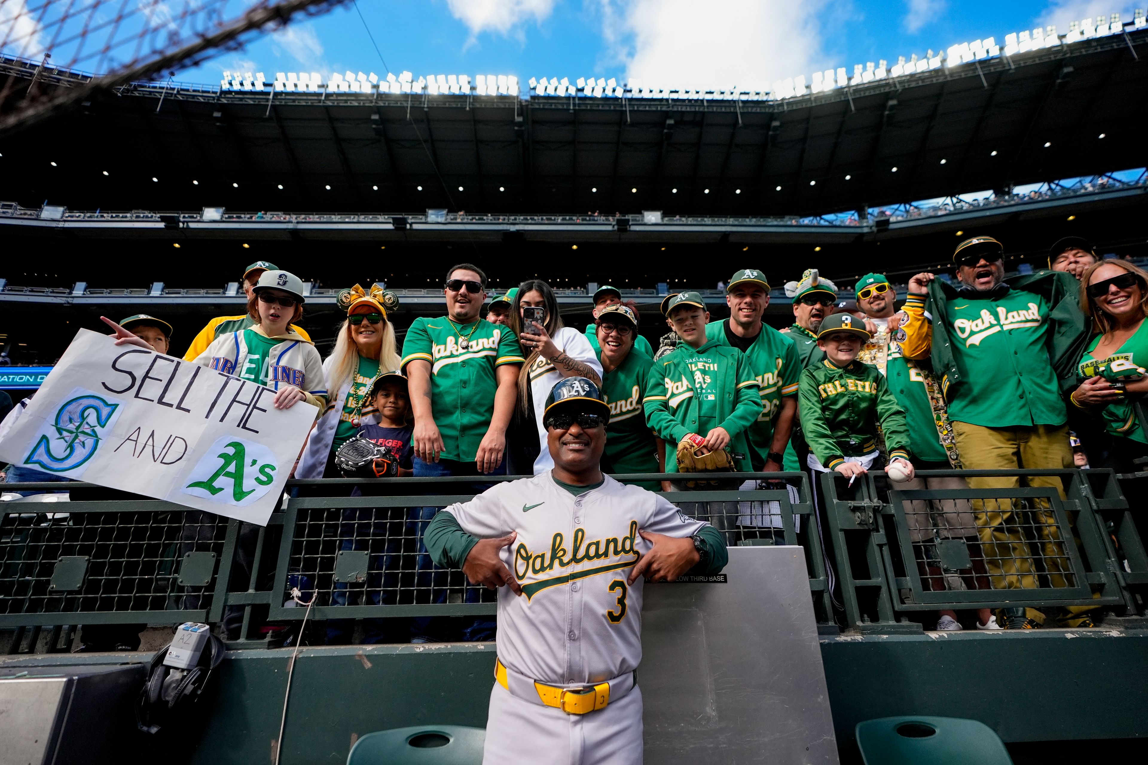 Oakland Athletics third base coach Eric Martins (3) poses with fans before a baseball game against the Seattle Mariners, Sunday, Sept. 29, 2024, in Seattle. (AP Photo/Lindsey Wasson)