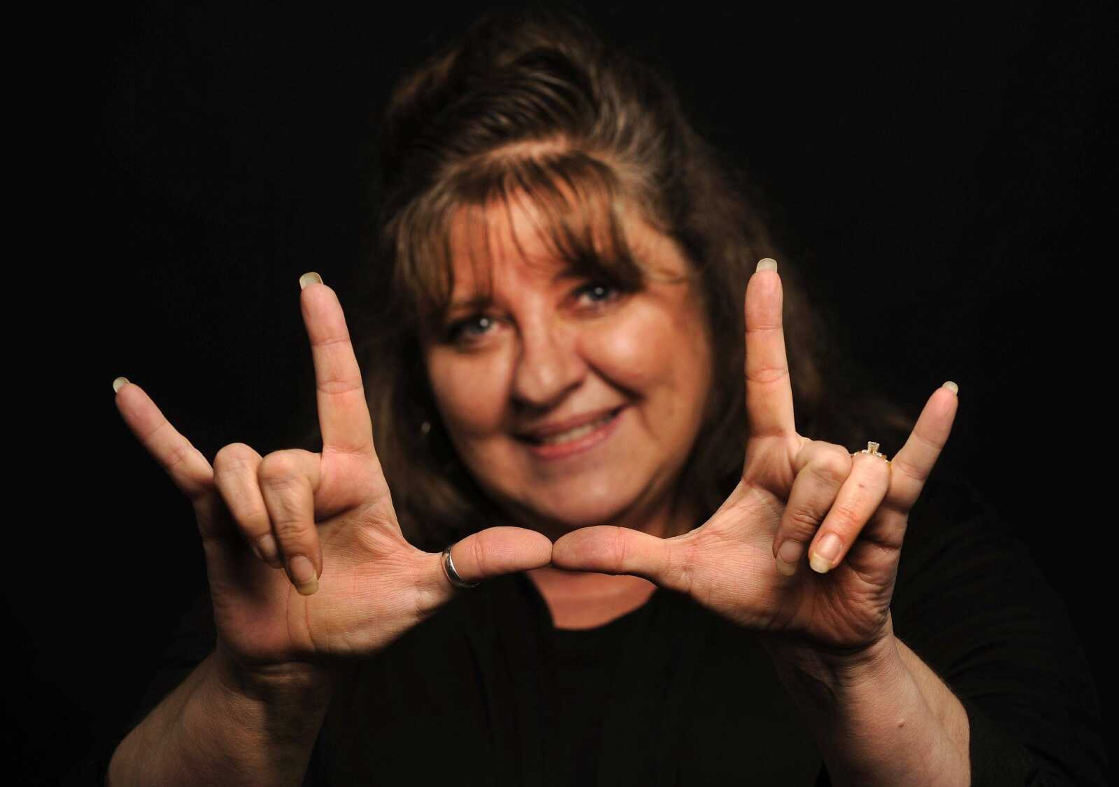 Jackie Cole signs "I love you," a common phrase in the sign language community.