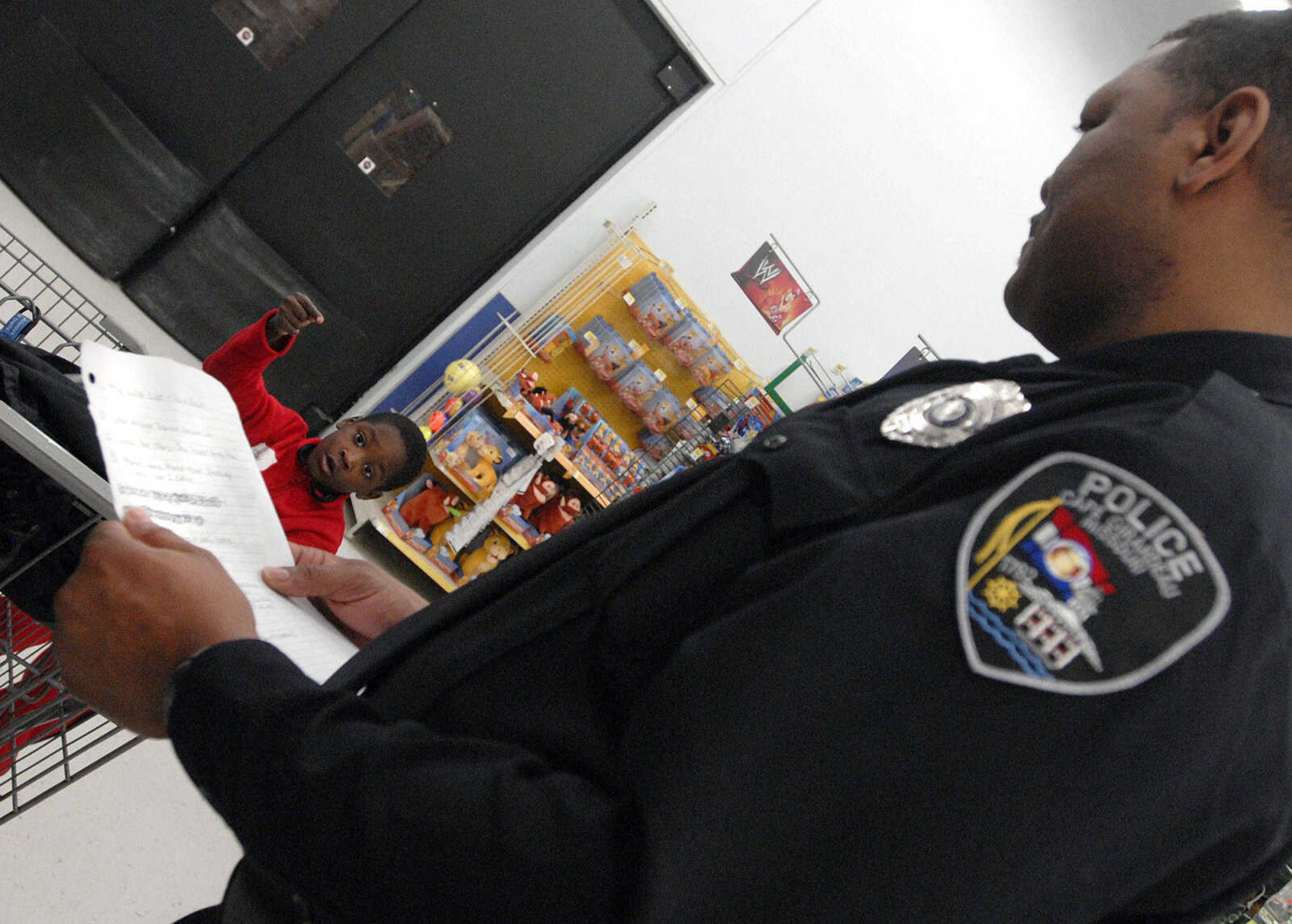 LAURA SIMON ~ lsimon@semissourian.com
Devin Rowe helps direct Cape Girardeau DARE officer Luther Bonds to the next item on his list Tuesday morning, Dec. 6, 2011 at Walmart in Cape Girardeau. Rowe was one of around 100 children that got to Shop with a Hero Tuesday morning. This is the 20th year that Walmart has held the Christmas shopping event that allows children to shop with donated money for toys, clothing or any item of their choice within the amount raised. This year each child received around $85 to spend with the help of local police officers, firefighters and first responders.