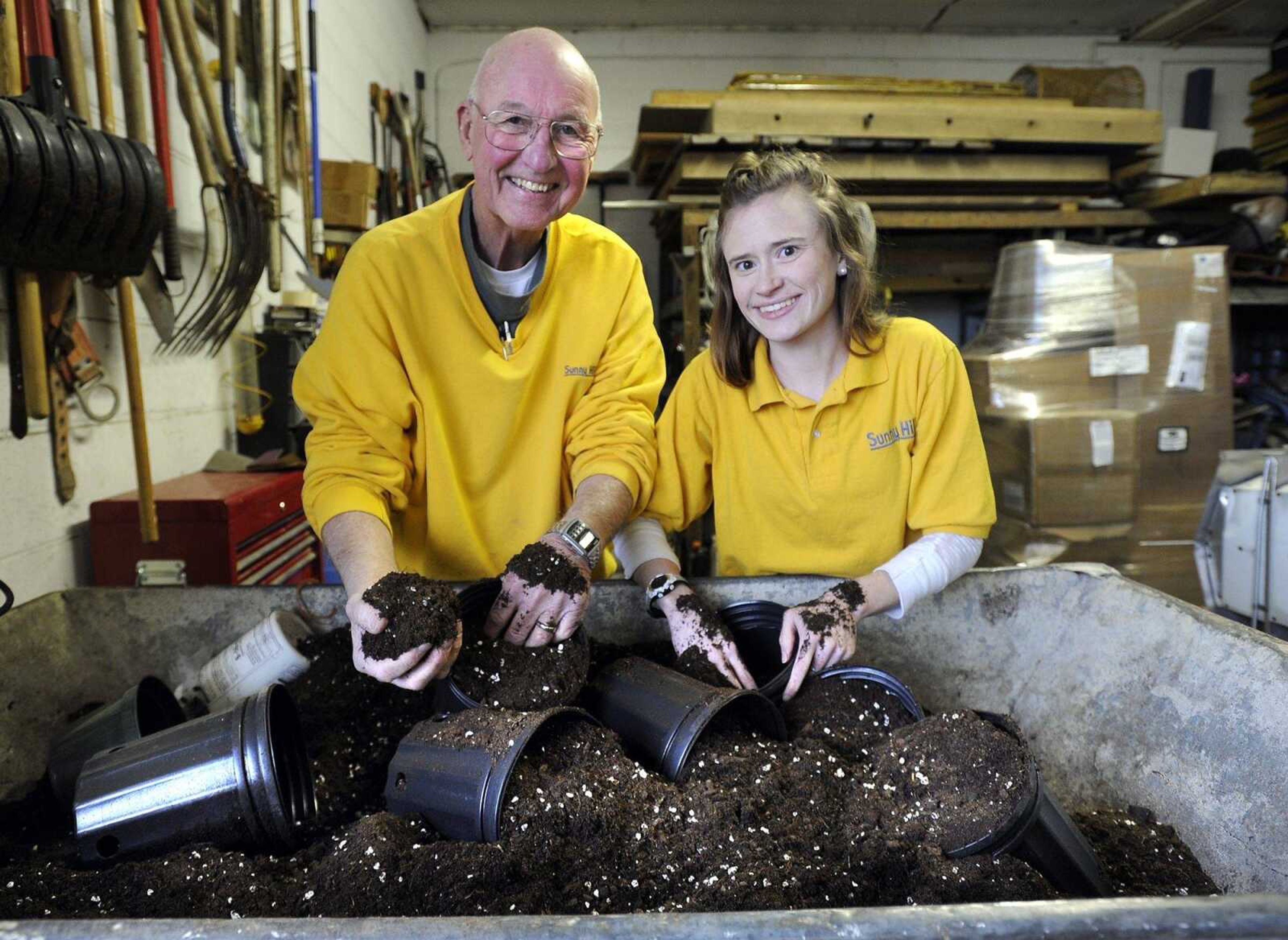 Paul Schnare and his granddaughter, Kelsi Siebert, play with potting soil Thursday as they reminisce of times together 20 years ago at Sunny Hill Gardens and Florist in Cape Girardeau.