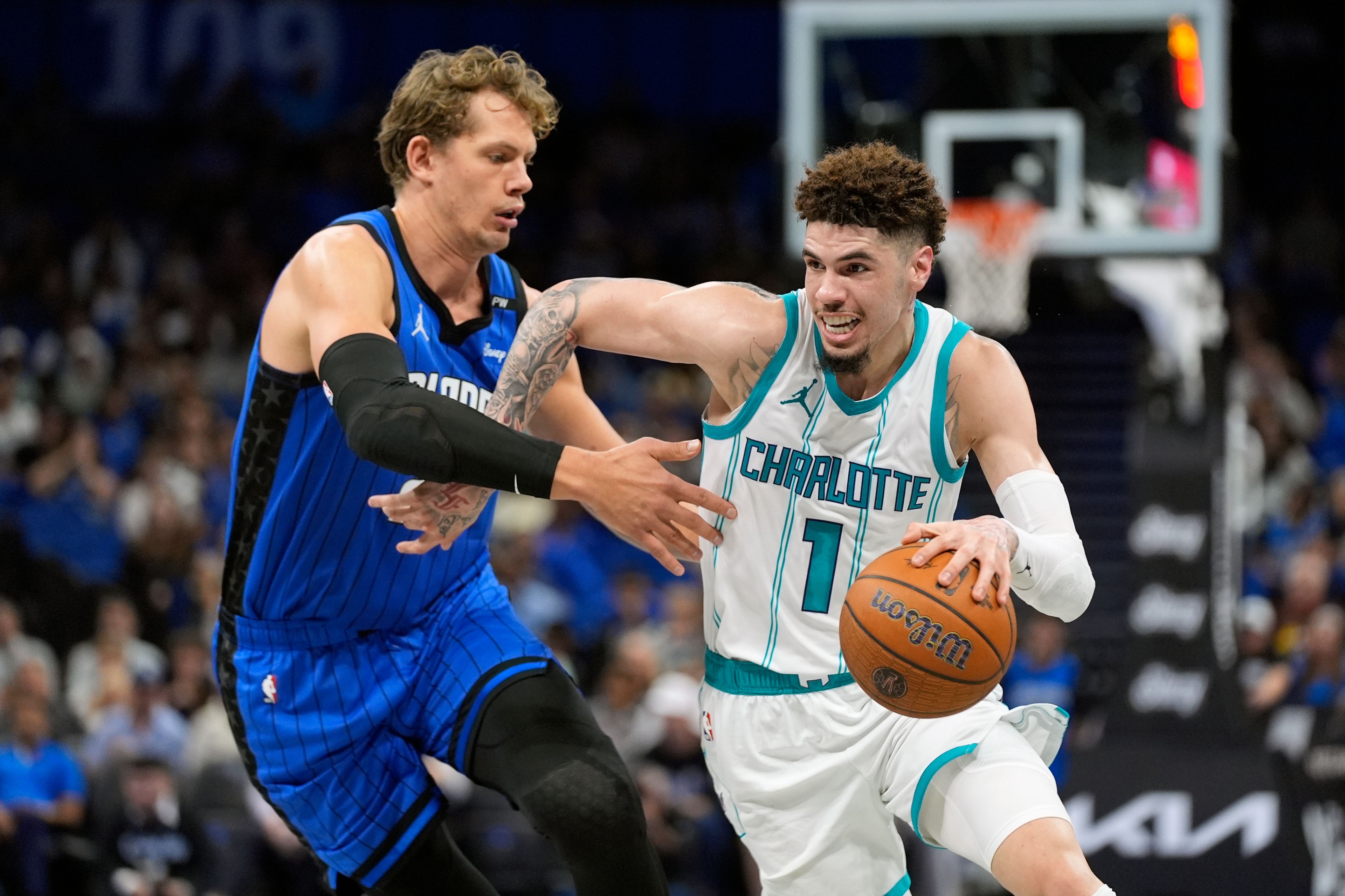 Charlotte Hornets guard LaMelo Ball (1) drives past Orlando Magic center Moritz Wagner, left, during the first half of an Emirates NBA Cup basketball game, Tuesday, Nov. 12, 2024, in Orlando, Fla. (AP Photo/John Raoux)