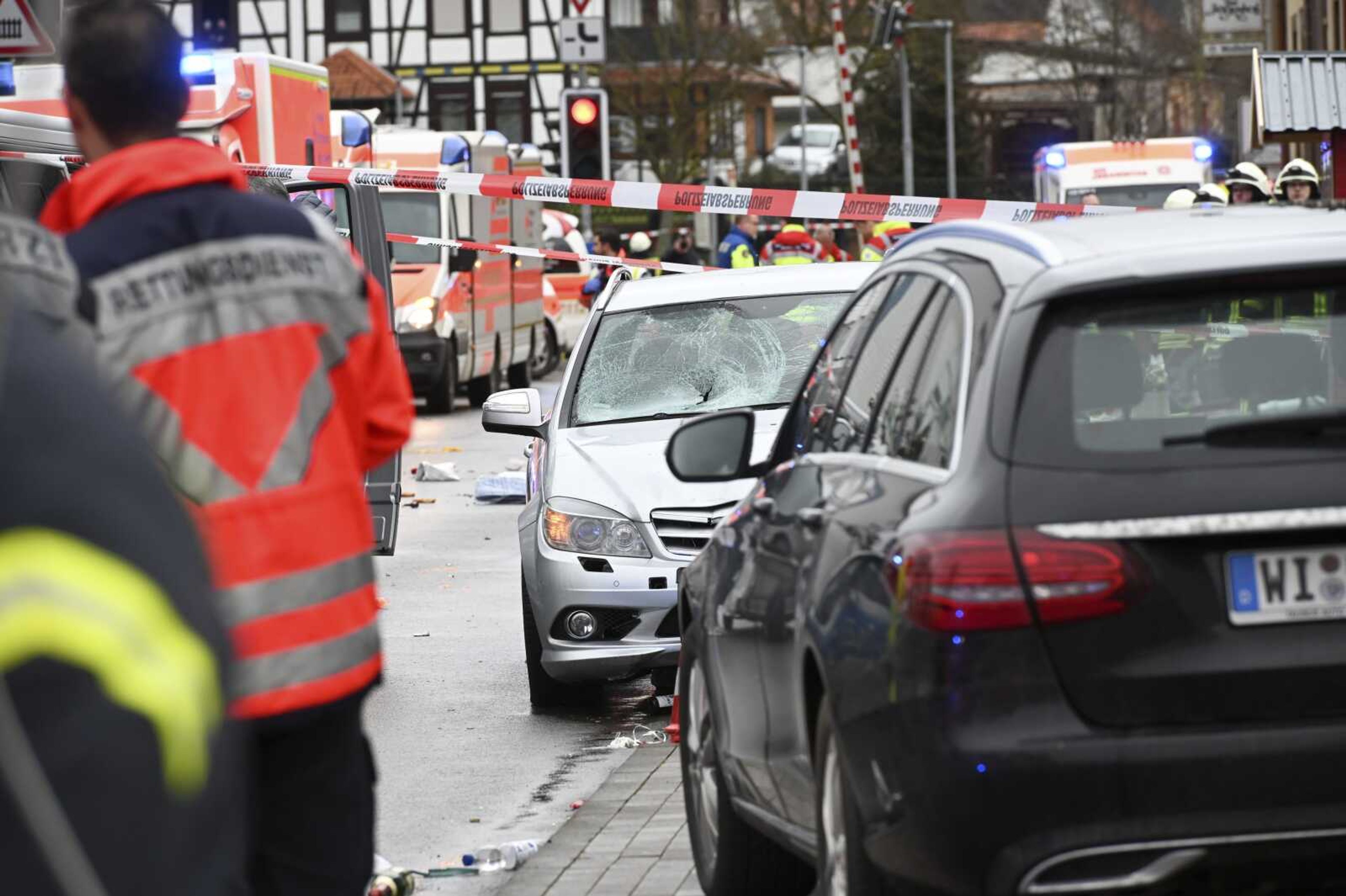 Police and rescue workers stand next to the scene of the accident with a car that is said to have crashed into a carnival parade in Volkmarsen, central Germany, Monday, Feb. 24, 2020. Several people have been injured, according to the police. The driver had been arrested by the police. (Uwe Zucchi/dpa via AP)