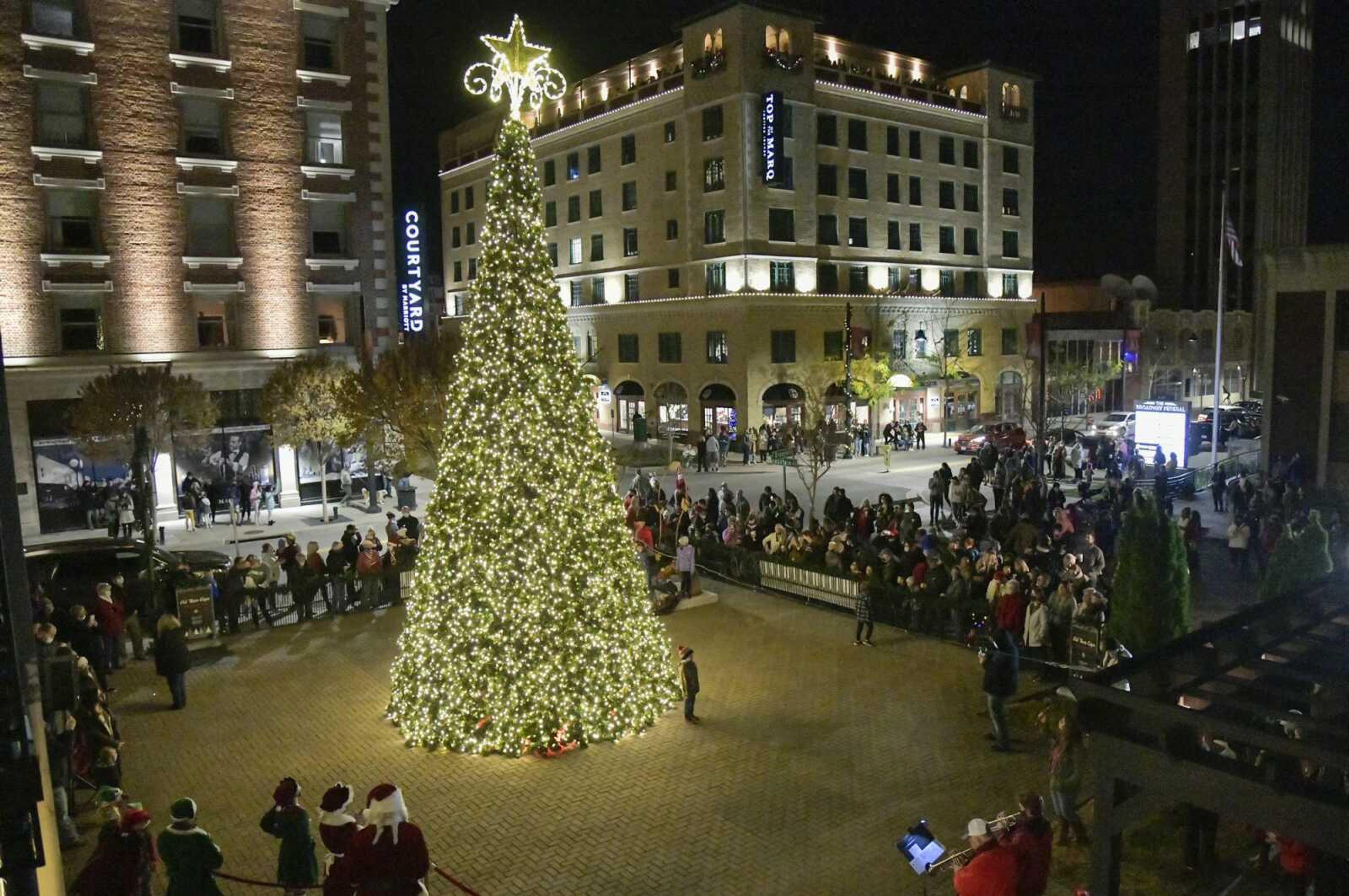 A mostly masked-up crowd cheers when Santa Claus and Mrs. Claus flip the switch Friday a few moments after the first attempt had technical difficulties at the Vasterling Suites Courtyard in Cape Girardeau.