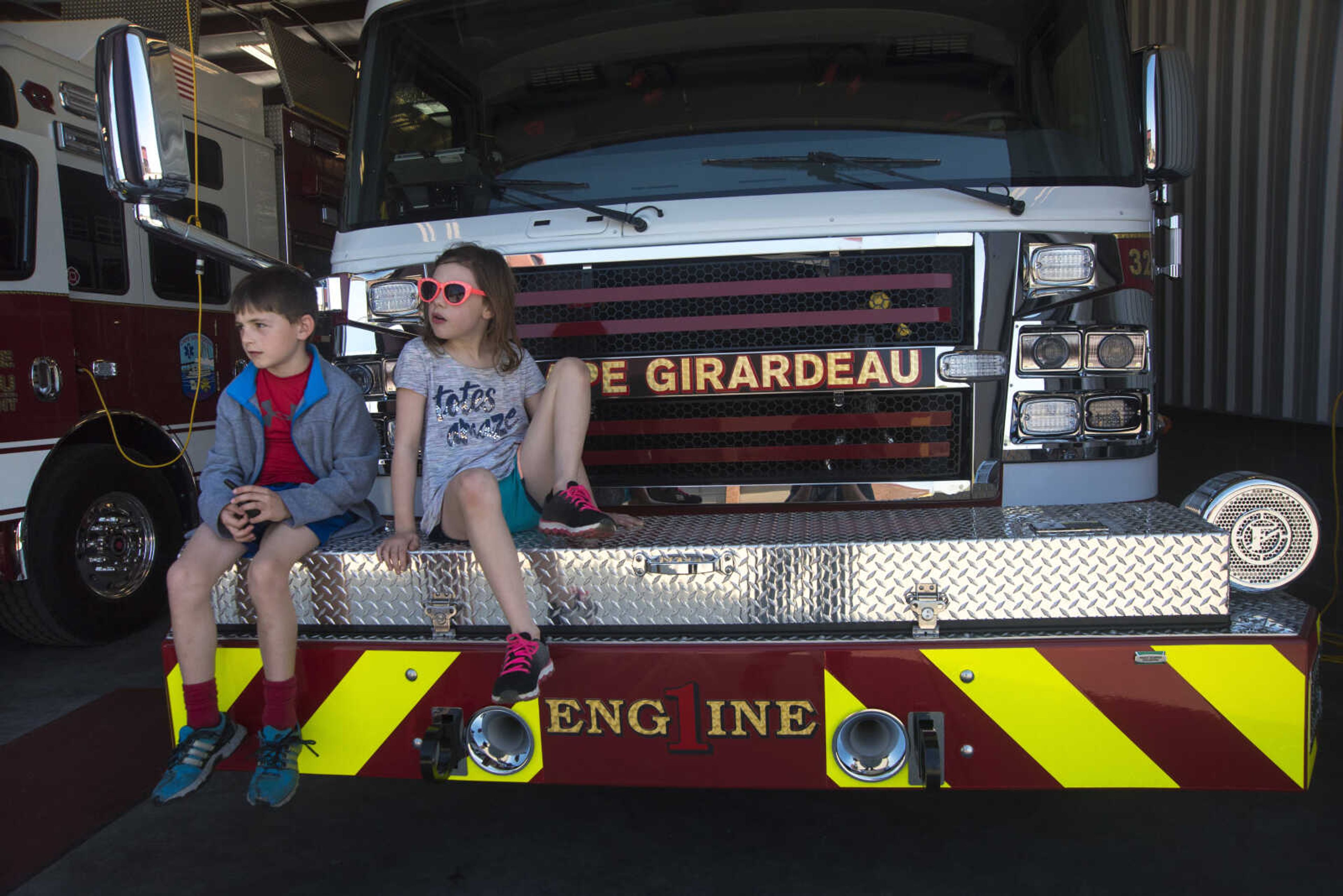 Adrian Stuart, 8, and Lauren Merchant, 7, sit on the front of a fire truck during the showing of the six Cape Girardeau fire trucks purchased at fire station number two Saturday, April 15, 2017 in Cape Girardeau. The National Fire Protection Association recommends fire departments to rotate their fleet every 10 years costing approximately $3.8 million dollars.