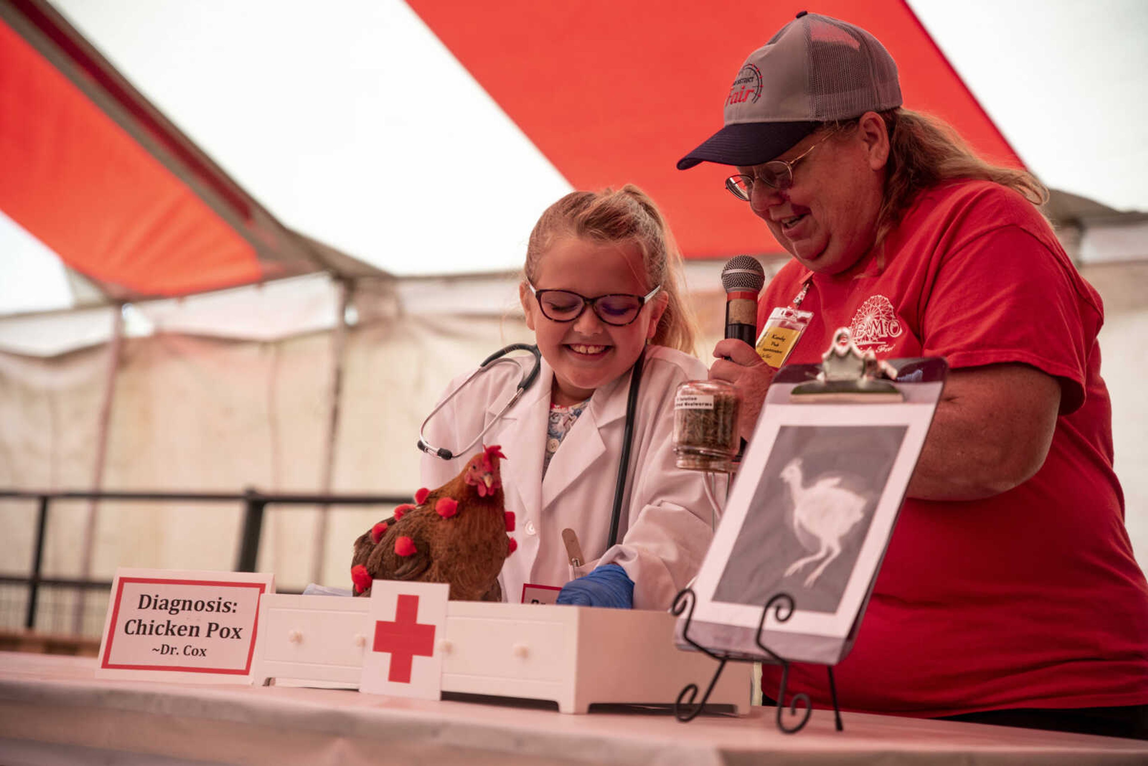 Lauren Cox, 8, laughs while answering questions as Kandy Peek emcees the Poultry and Rabbit Dress-Up Contest at the SEMO District Fair Sunday, Sept. 9, 2018 in Cape Girardeau.