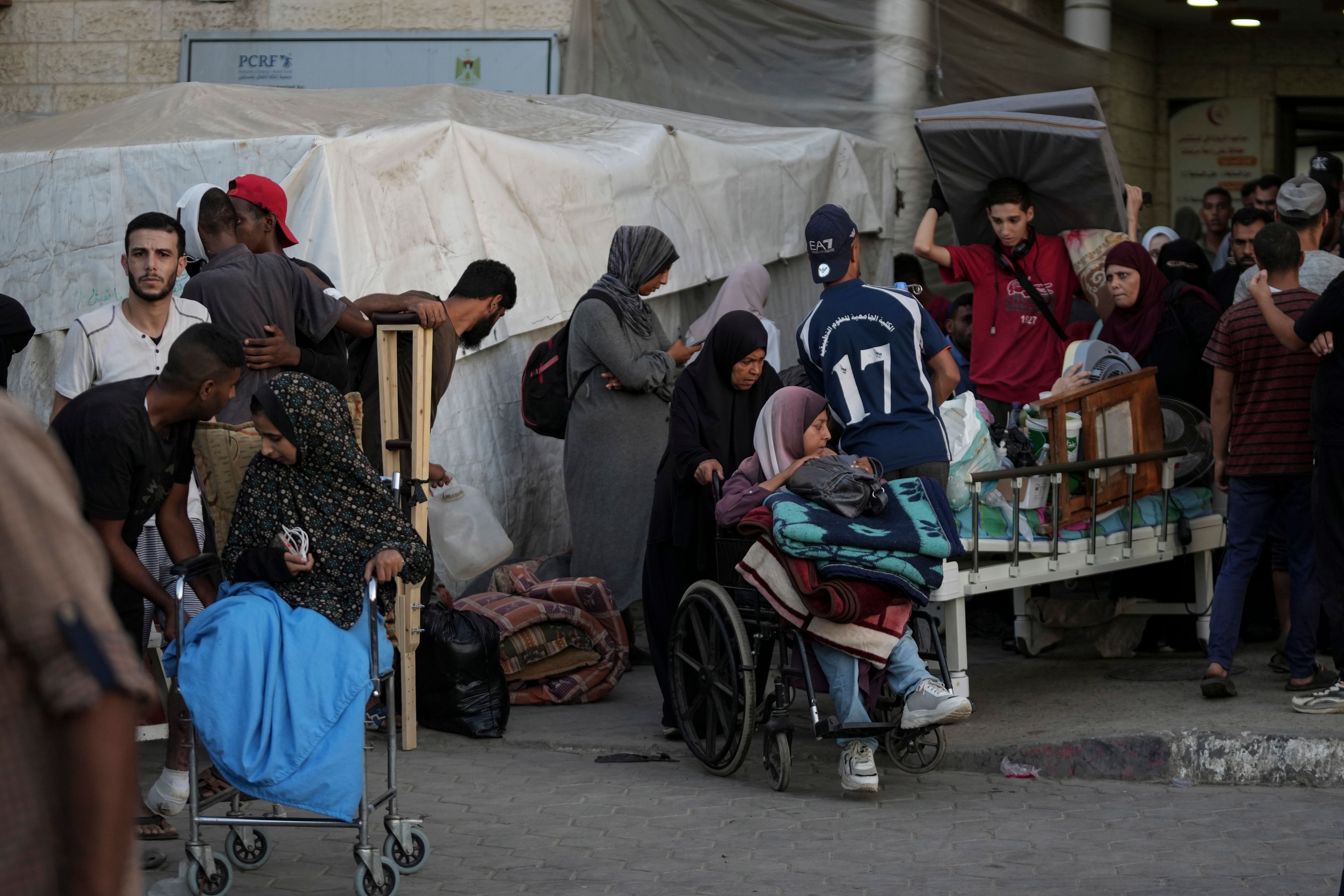 Patients and families move outside the Al-Aqsa Martyrs Hospital in Deir al Balah, Gaza Strip, Sunday, Aug. 25, 2024. (AP Photo/Abdel Kareem Hana)