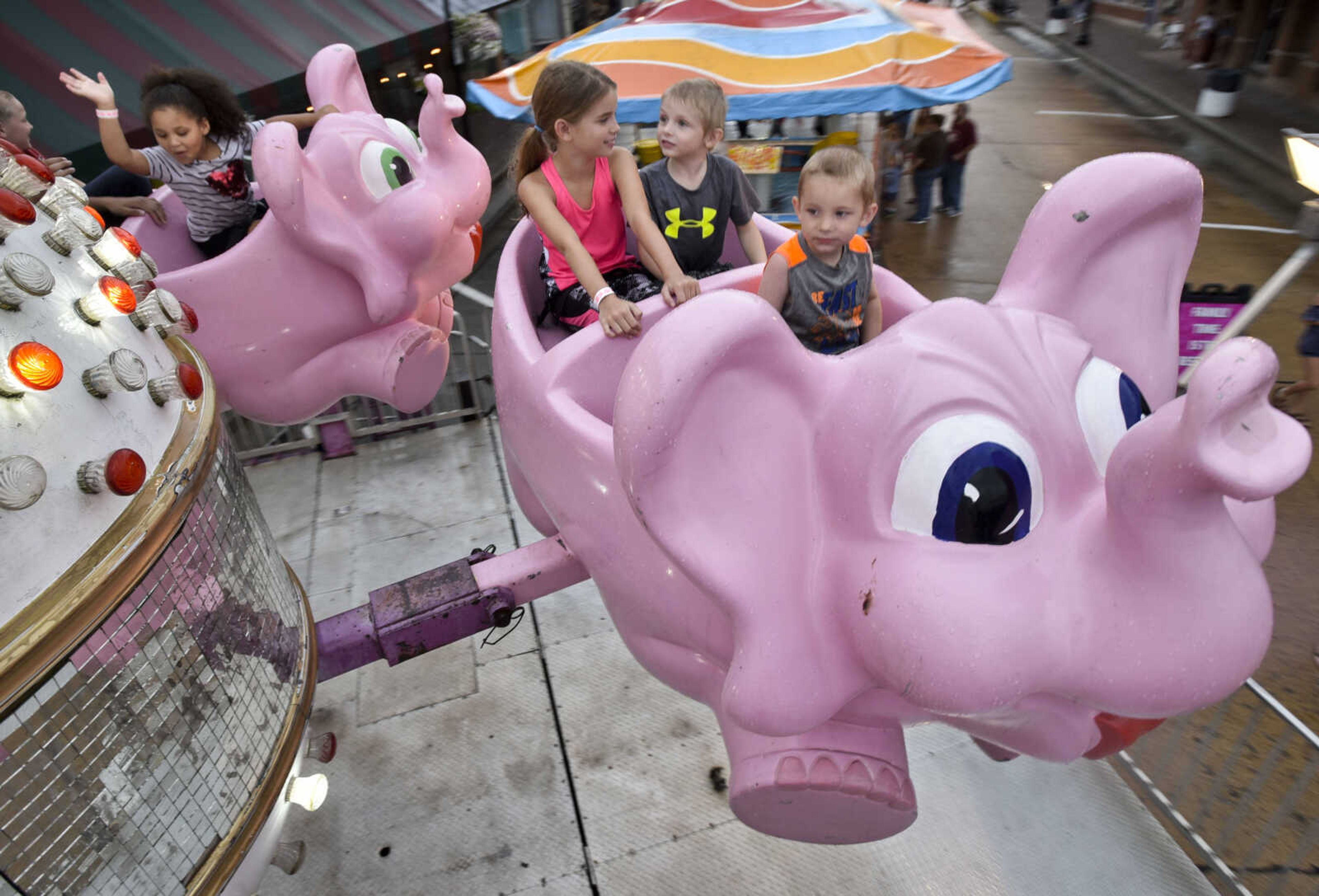 From right, Greyson Rueseler, 2, Braydon Dohogne and Emma Rueseler, 9, sit together while riding the elephants on Thursday, July 27, 2018 at Jackson Homecomers.