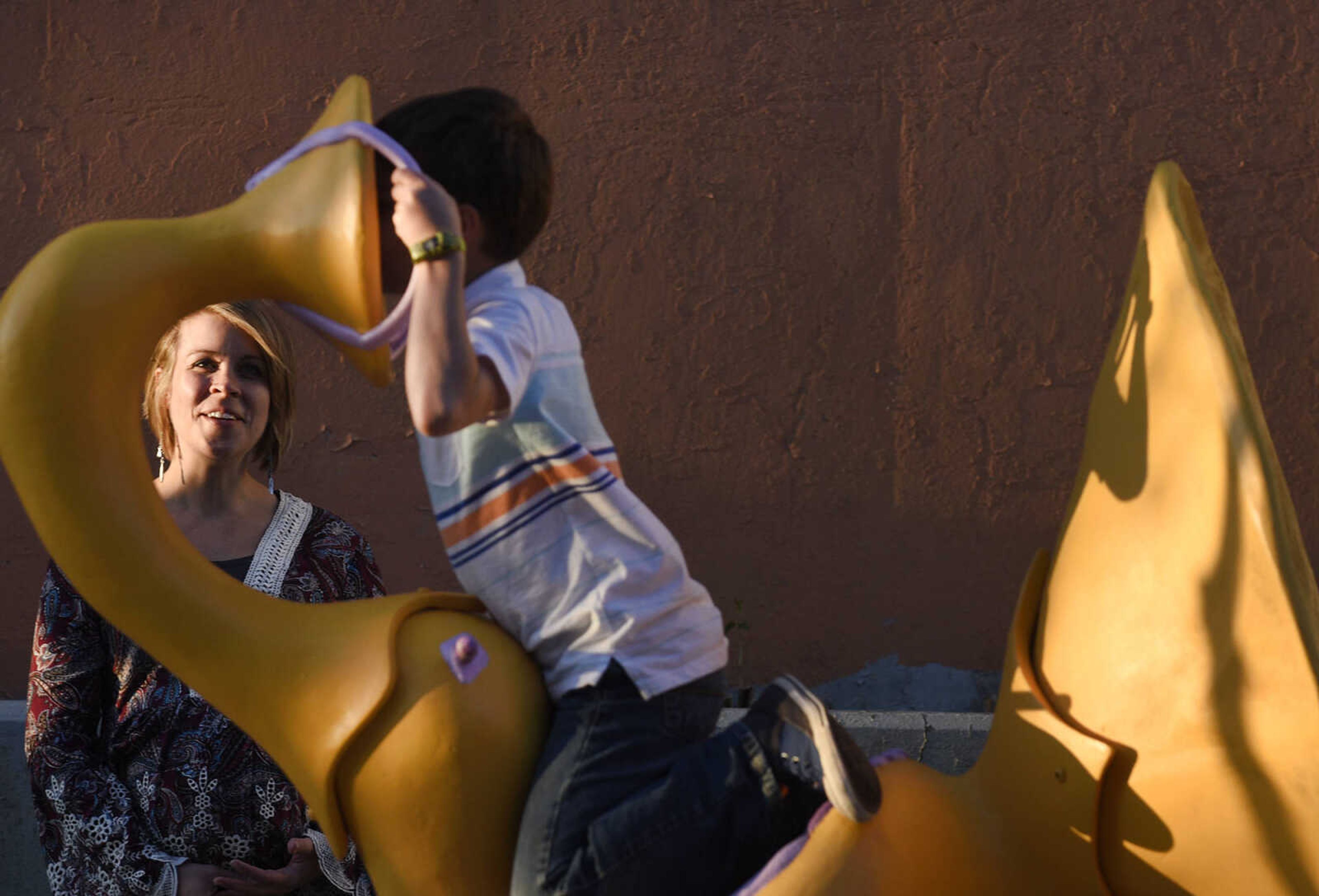 Jillian Springer watches her son, Theodore Butterfield, 9, play on her interactive sculpture "Grandiloquence" near the intersection of Broadway and Frederick Street on Thursday evening, April 6, 2017, in Cape Girardeau. Springer's sculpture is one of seven new sculptures installed along Broadway as part of the Cape Girardeau Outdoor Sculpture Exhibit.