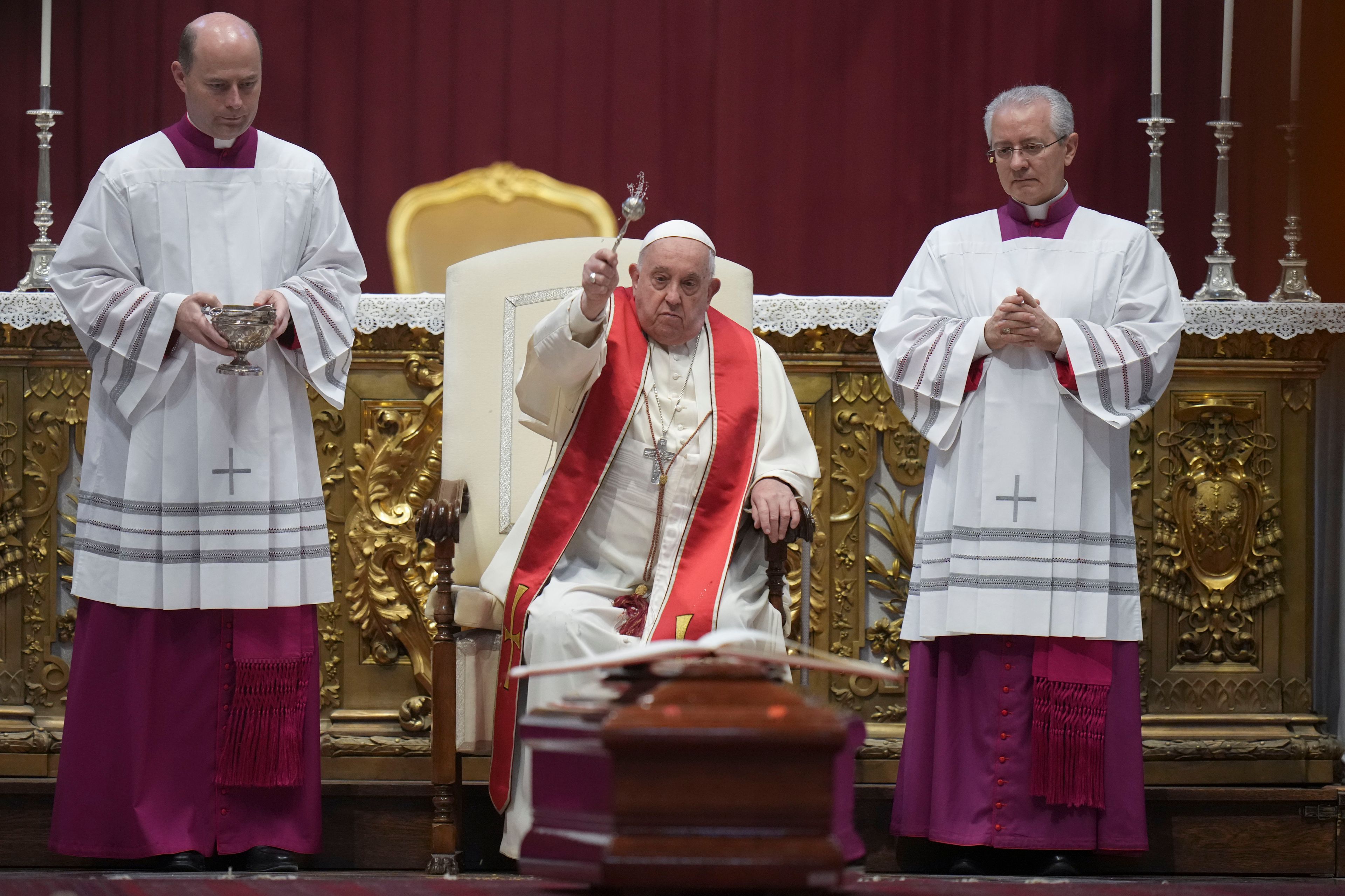 Pope Francis asperges the coffing with the body of late Cardinal Miguel Ángel Ayuso Guixot during his funeral in St. Peter's Basilica at The Vatican Wednesday, Nov. 27, 2024. (AP Photo/Alessandra Tarantino)