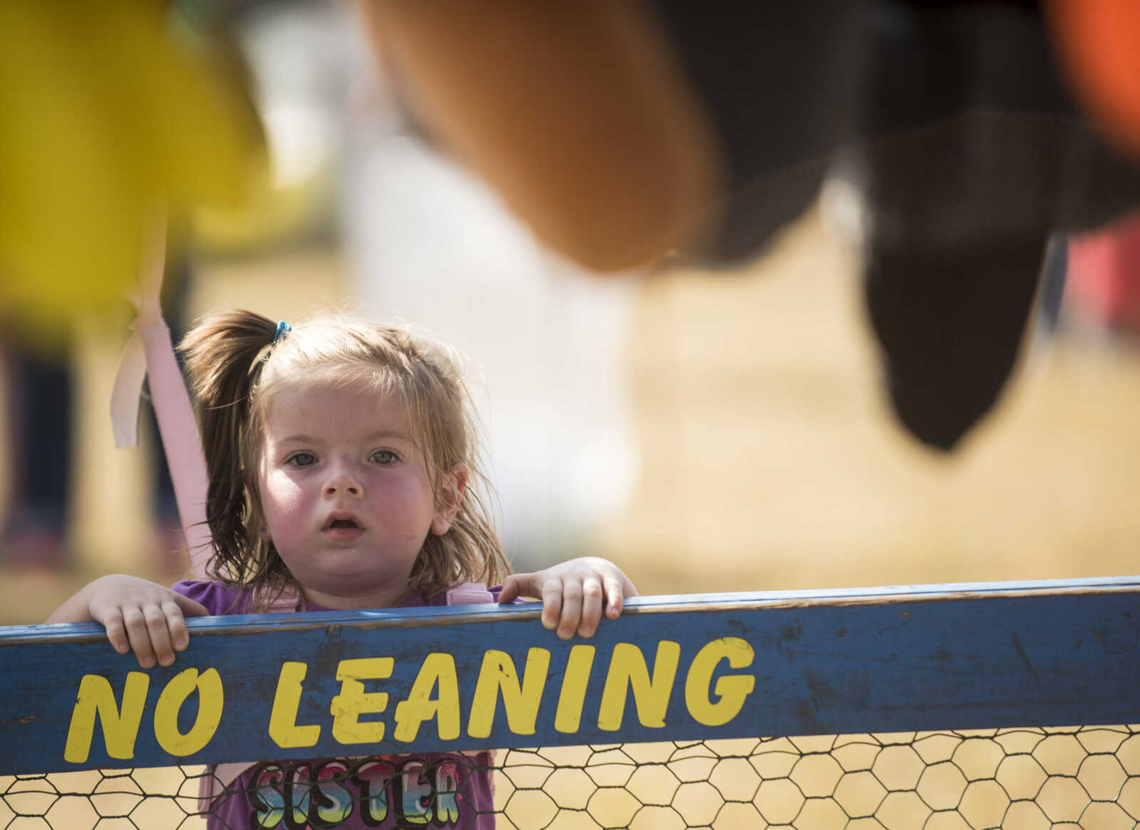 Kinley Dees, 2, watches fairgoers play a carnival game Sept. 23, 2017 in the midway at the East Perry Community Fair in Altenburg, Missouri.