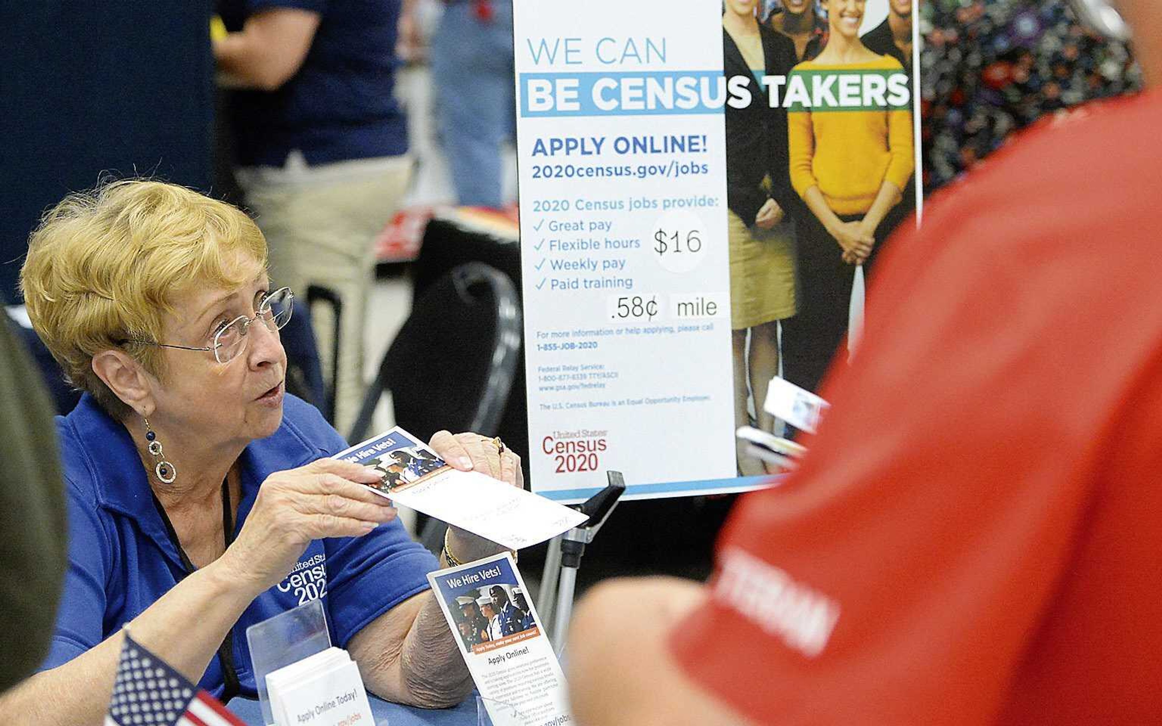 In this Oct. 2, 2019, file photo, Joyce Dalbey of the U.S. Census Bureau talks to attendees at the Yuma Community Job and Education Fair about possible job opportunities with the federal agency in Yuma, Arizona.