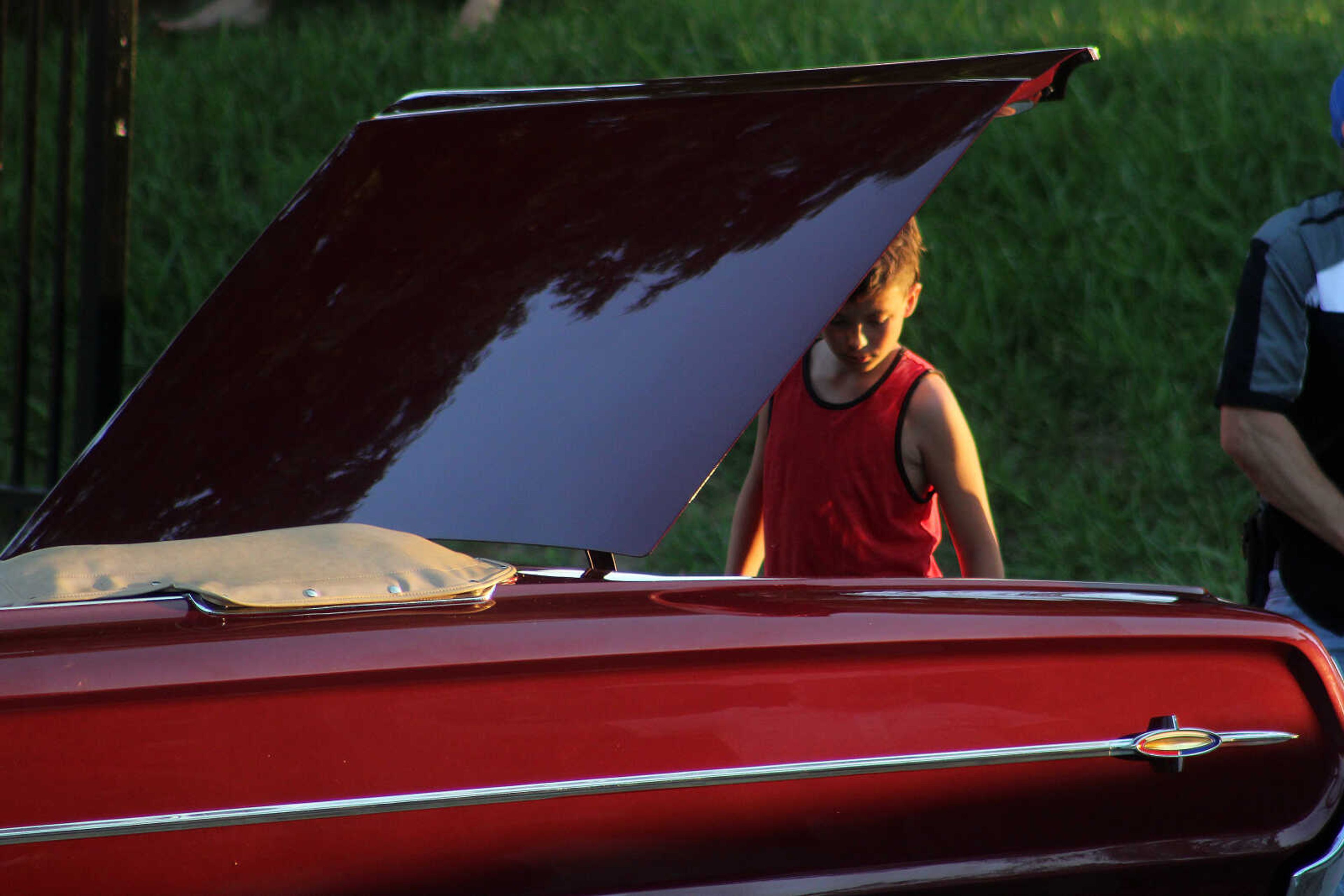 Adrian Prasanphanich, 12, looks under the hood of his grandfather's antique car during the Cruisin Uptown Car Show Saturday, June 13, at 101 Court Street in Jackson.