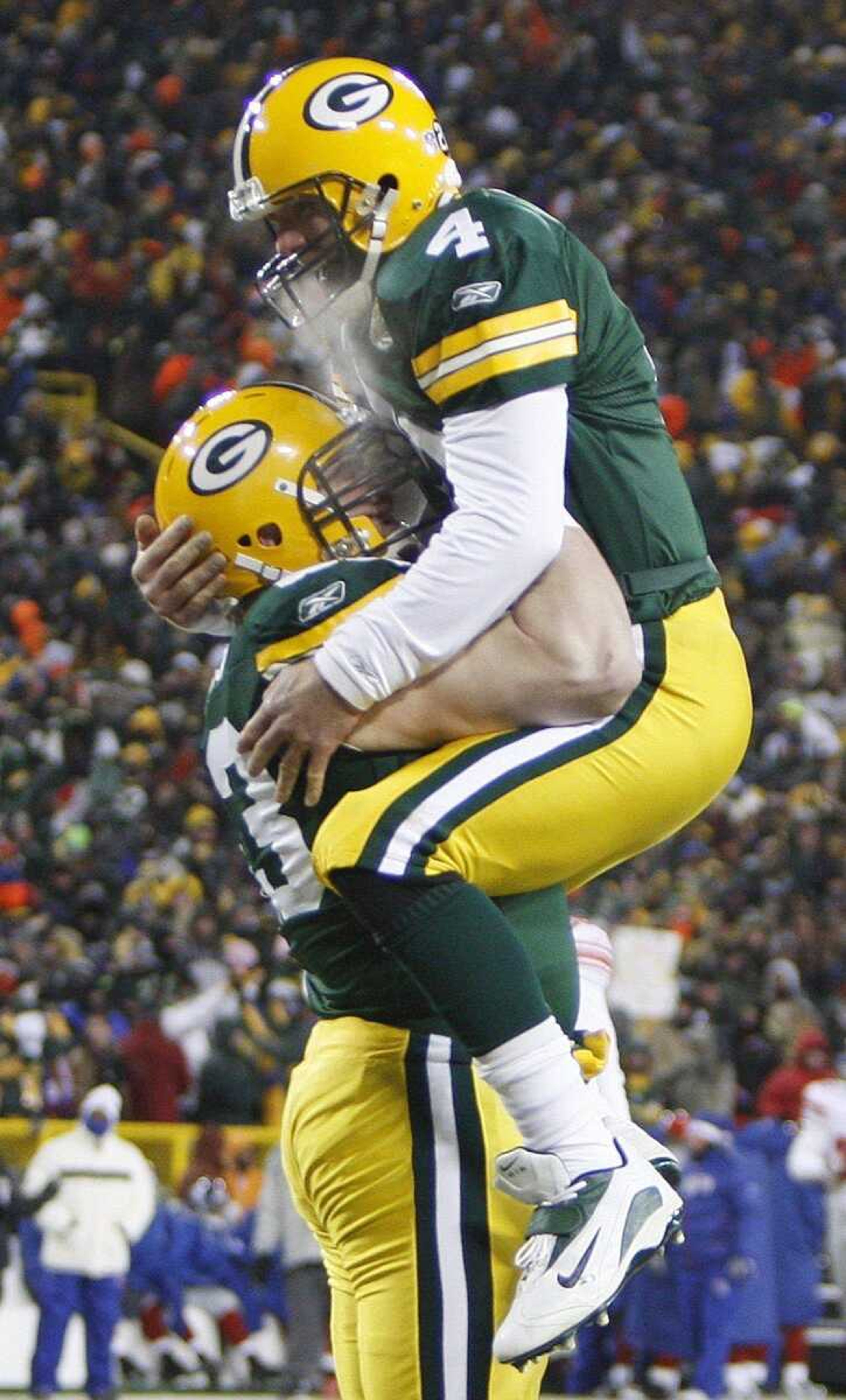 Green Bay Packers quarterback Brett Favre (4) leaps into the arms of center Scott Wells after throwing a touchdown pass to Donald Driver during the NFC Championship football game against the New York Giants, Sunday, Jan. 20, 2008, in Green Bay, Wis. (AP Photo/Mike Roemer)