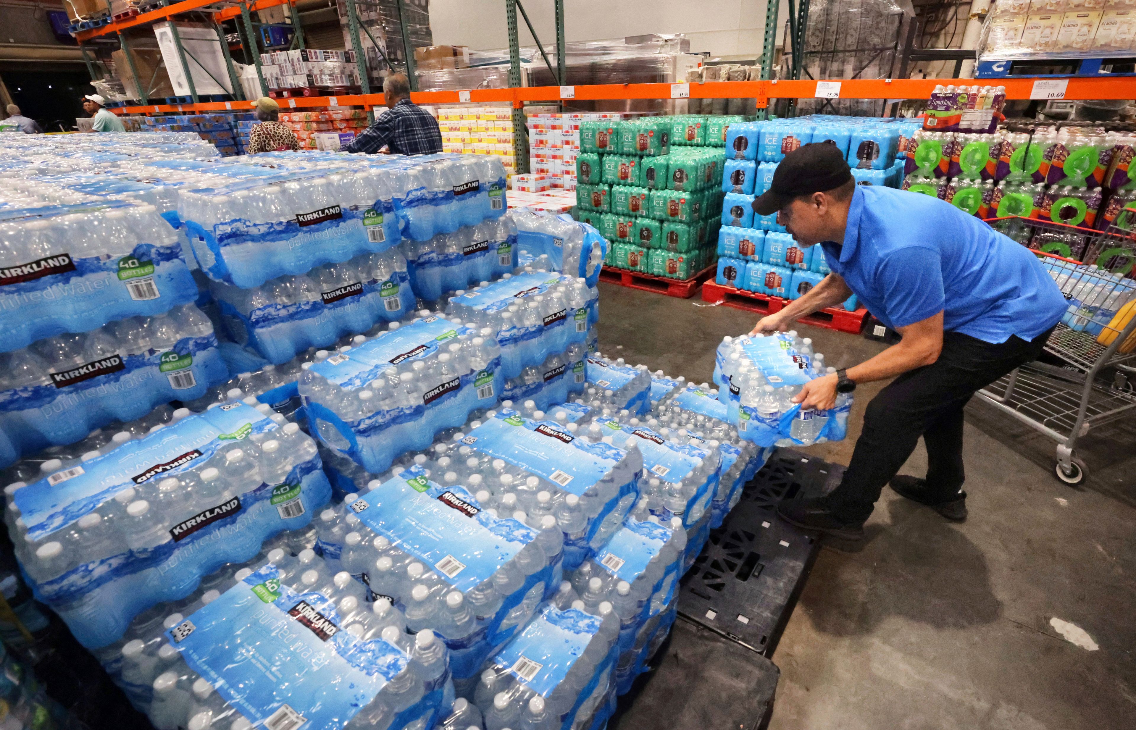 A customer grabs a case of water at the Costco in Altamonte Springs, Fla., Monday, Oct. 7, 2024, as residents prepare for the impact of Hurricane Milton. (Joe Burbank/Orlando Sentinel via AP)