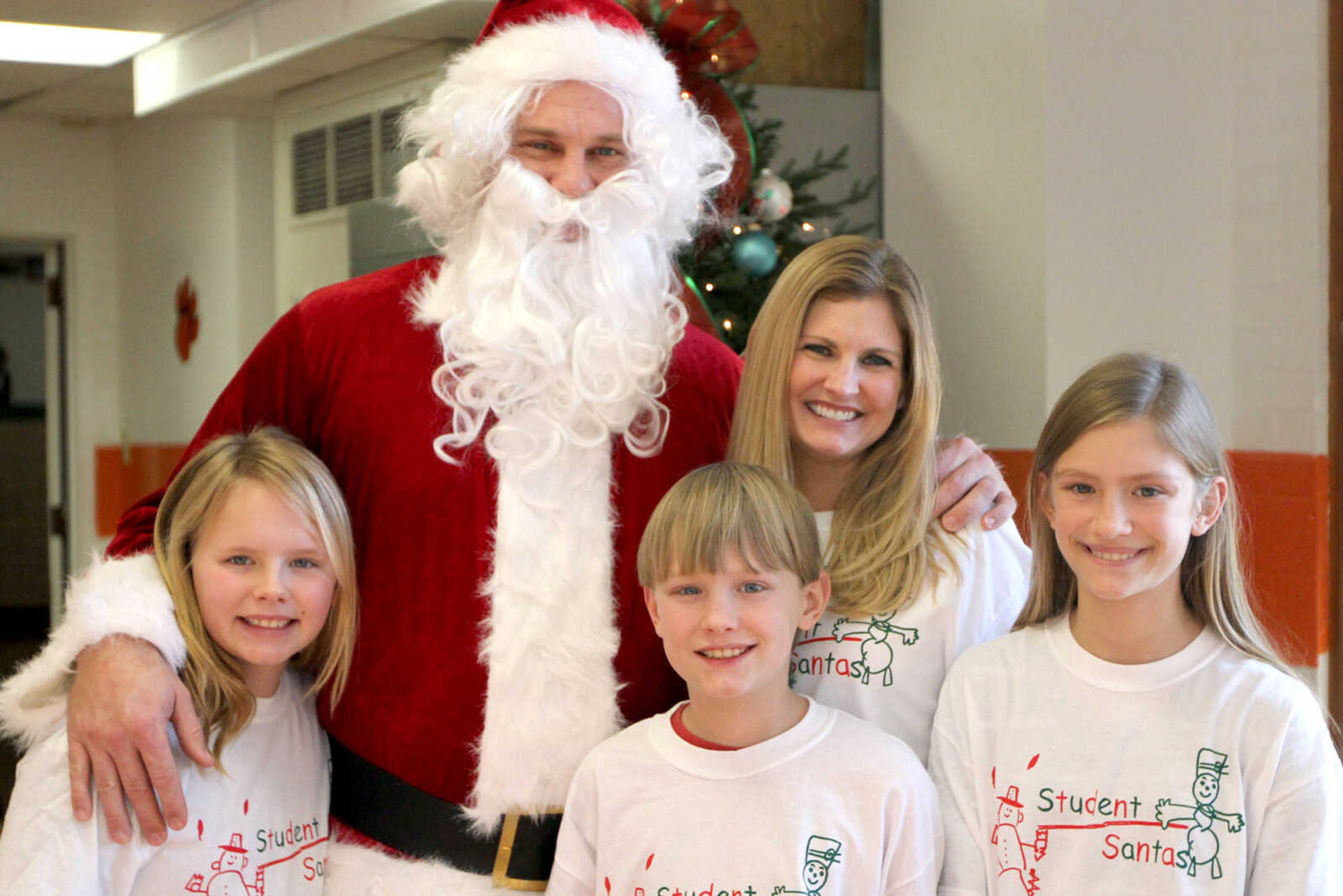 GLENN LANDBERG ~ glandberg@semissourian.com

Lisken Glass, left, Santa, Bryce Fisher, Krista Nickelson and Kayden Fisher pose for a photo during the Student Santas Christmas dinner Thursday, Dec. 25, 2014 at Central Junior High School.