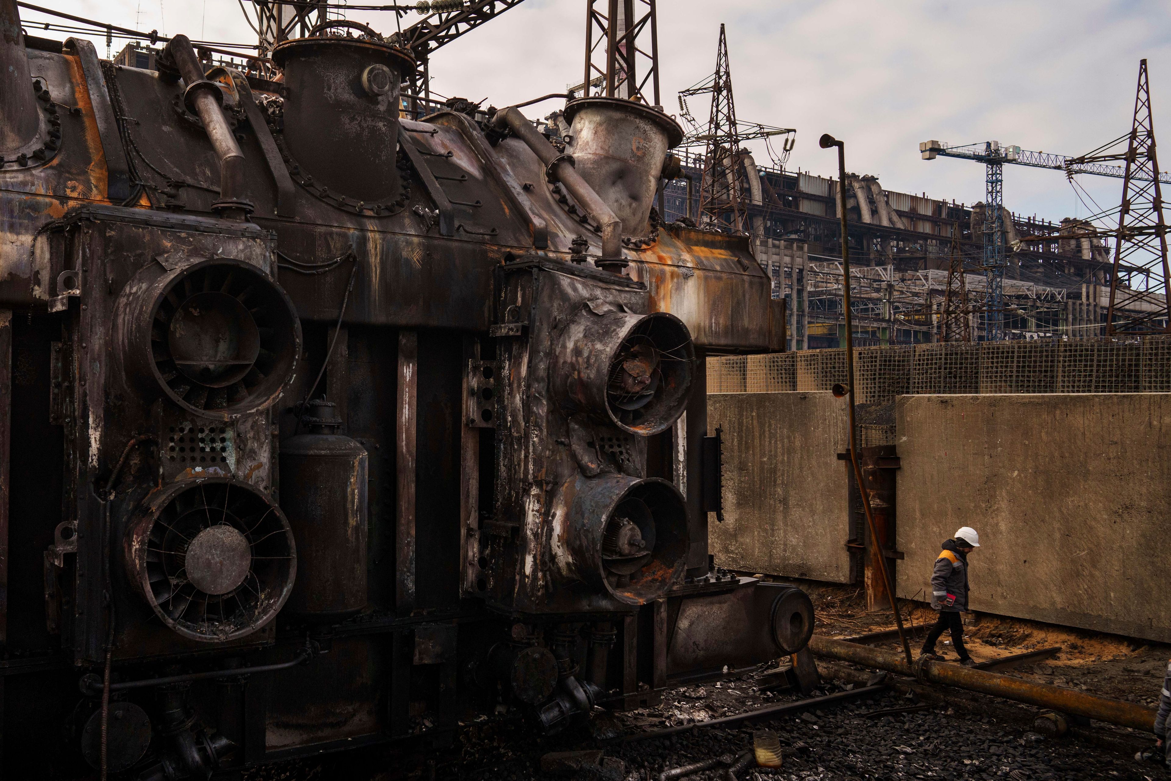 A worker walks in front of a transformer which was destroyed after a recent Russian missile attack at DTEK's power plant in Ukraine, Nov. 28, 2024. (AP Photo/Evgeniy Maloletka)