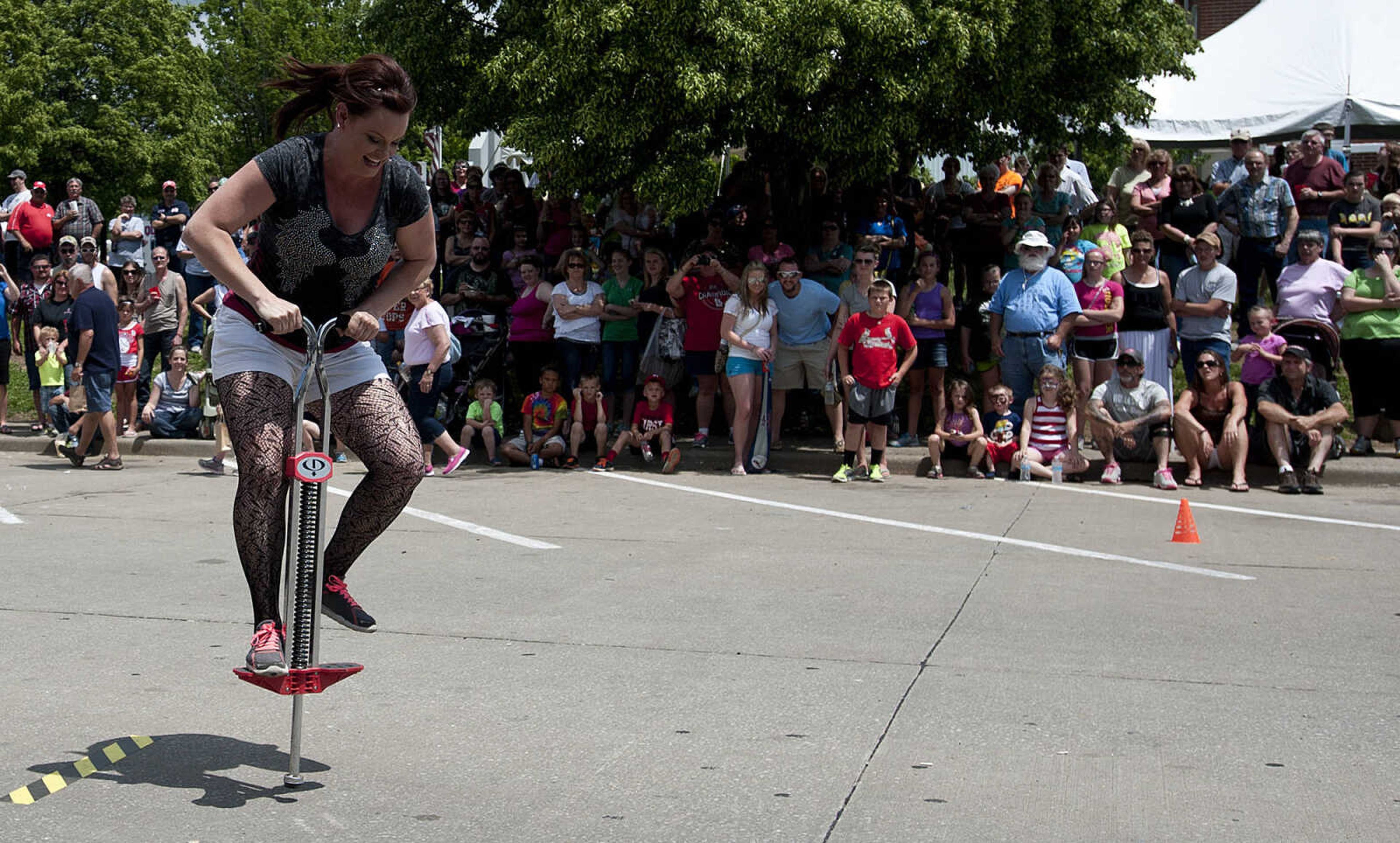 Misty Taylo rides a pogo stick while competing with the Biker Babes team in the Perryville Mayfest Bed Races Saturday, May 10, in Perryville, Mo.