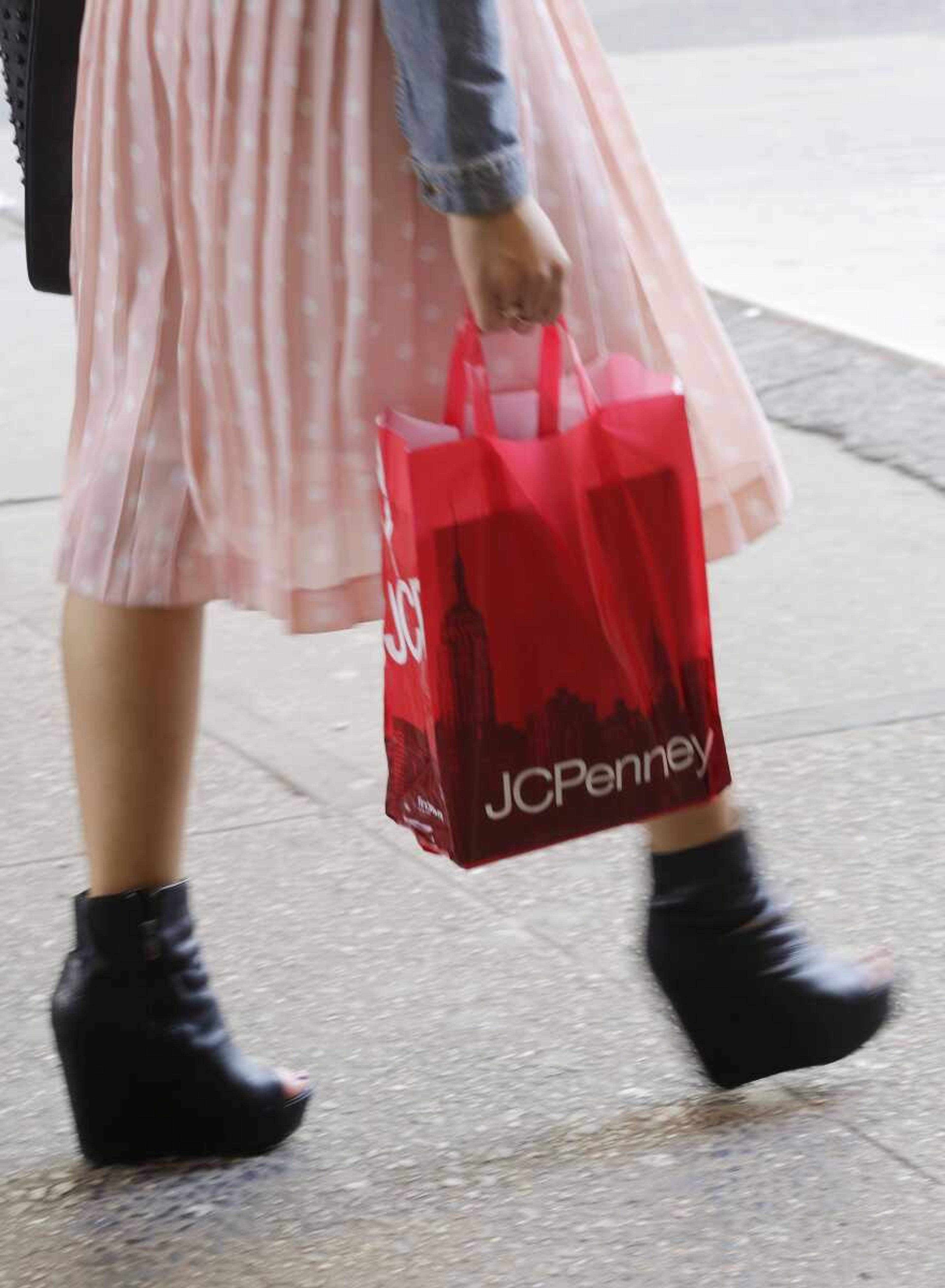 A shopper carries a J.C. Penney bag April 9 in New York. J.C. Penney is hoping its former CEO can revive the retailer after a risky turnaround strategy backfired and led to massive losses and steep sales declines. The company&#8217;s board of directors ousted CEO Ron Johnson after only 17 months on the job. The department store chain said that it has rehired Johnson&#8217;s predecessor, Mike Ullman. (AP Photo/Mark Lennihan)