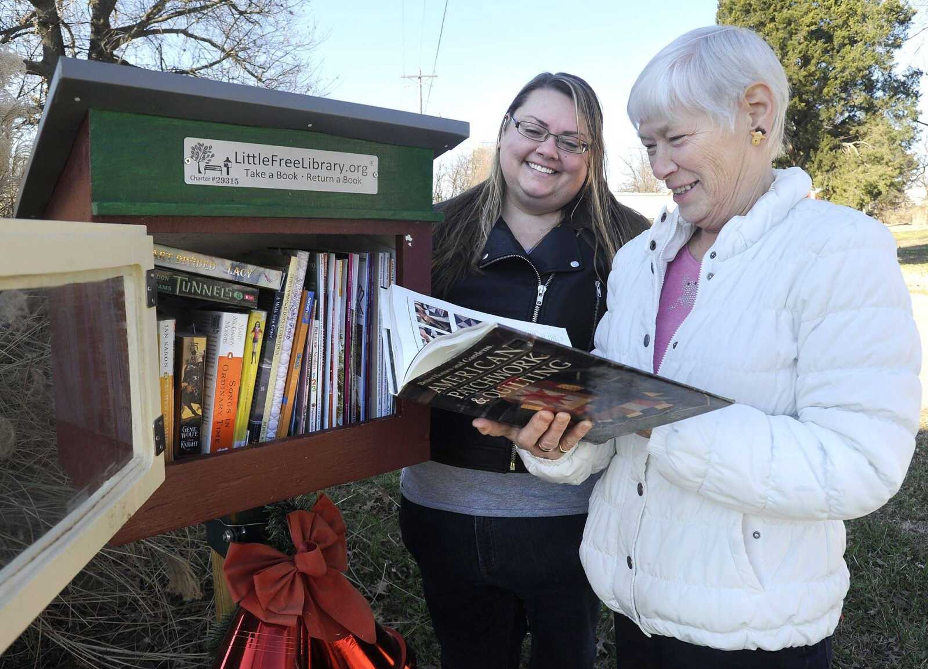 Doris Dace, right, and Becky LaClair show the Little Free Library in Pocahontas, Missouri. (Fred Lynch)