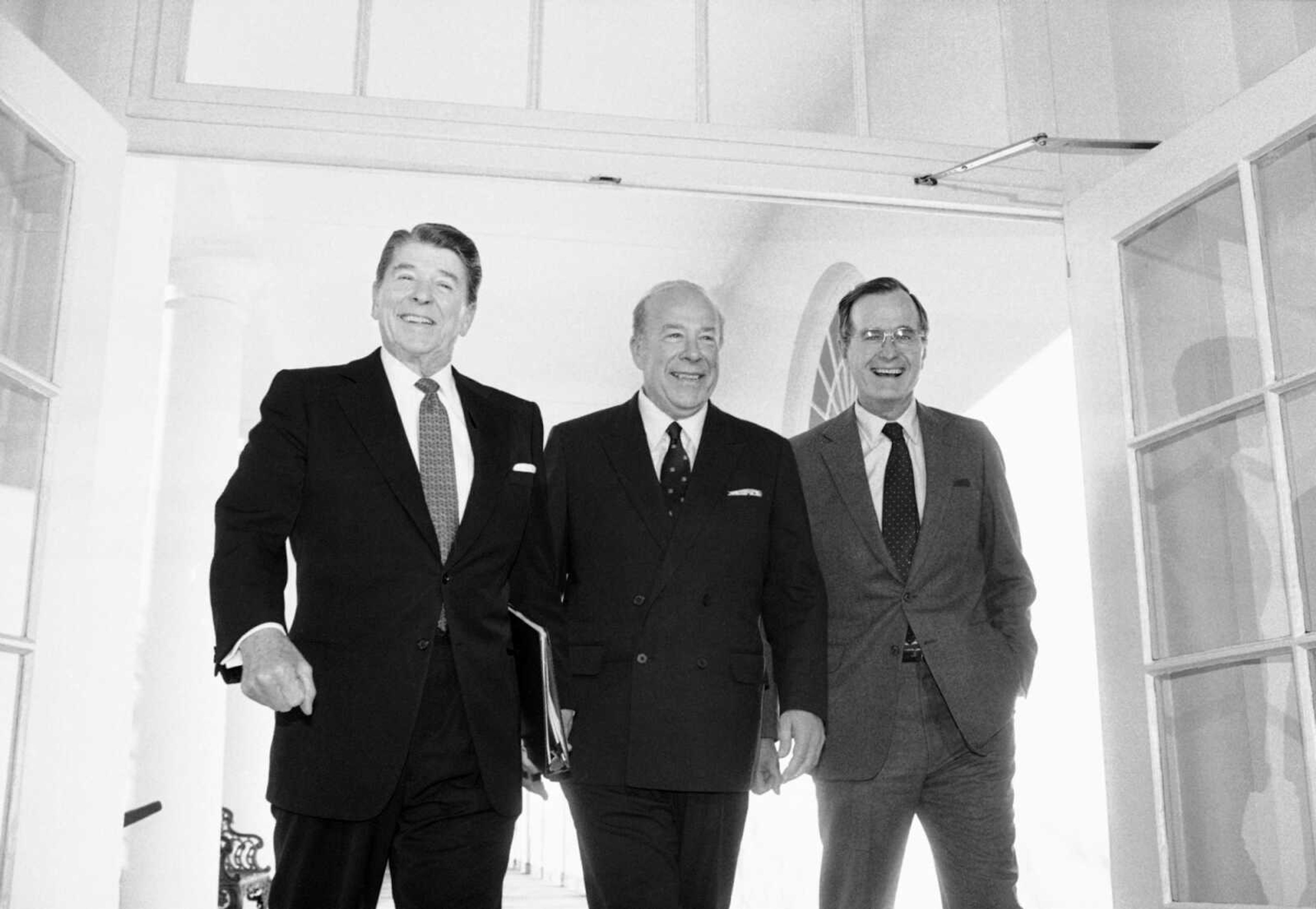 Secretary of State George Shultz, center, walks with President Ronald Reagan and Vice President George Bush upon his arrival at the White House on Jan. 9, 1985, in Washington, after two days of arms talks with the Soviet Union in Geneva.