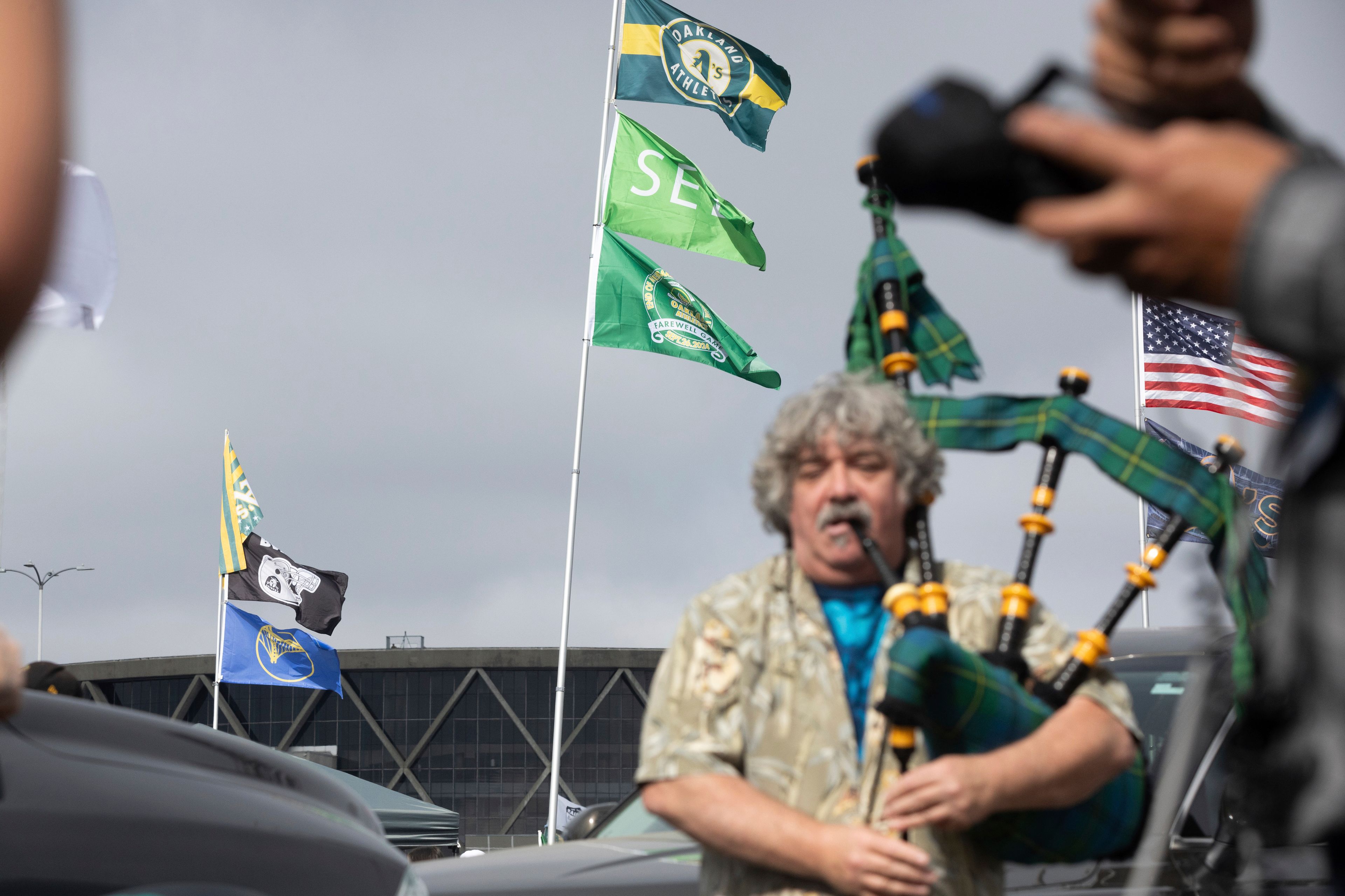 Andrew Johnstone plays the bagpipes outside the Oakland Coliseum before a baseball game between the Oakland Athletics and the Texas Rangers Thursday, Sept. 26, 2024, in Oakland, Calif. (AP Photo/Benjamin Fanjoy)