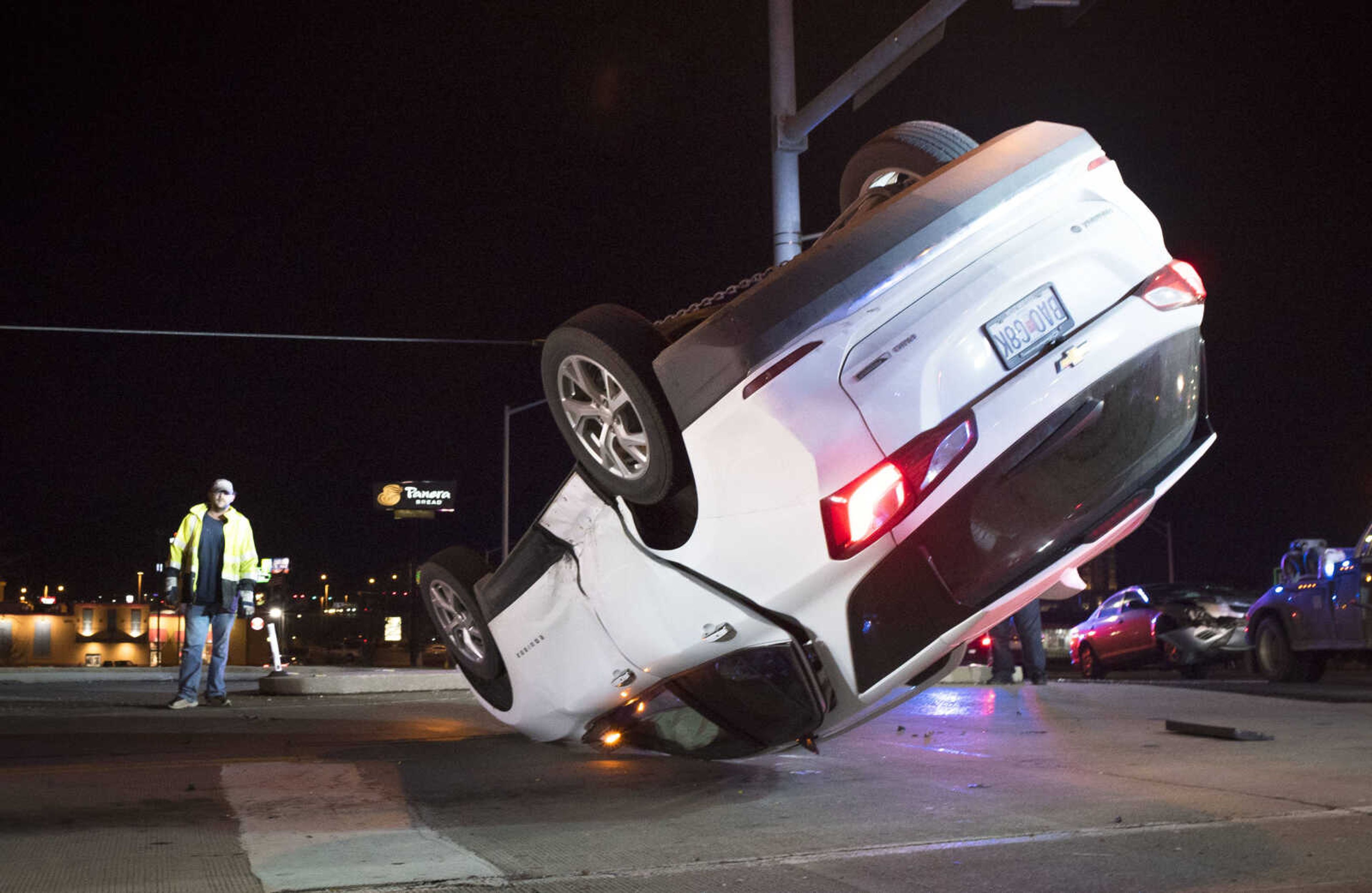 Emergency crews watch as a truck operator with Sperling's Garage and Wrecker Service pulls an overturned Chevrolet Equinox back onto its wheels at the scene of a two-car collision in the intersection of Mount Auburn Road and William Street on Monday, Dec. 9, 2019, in Cape Girardeau.