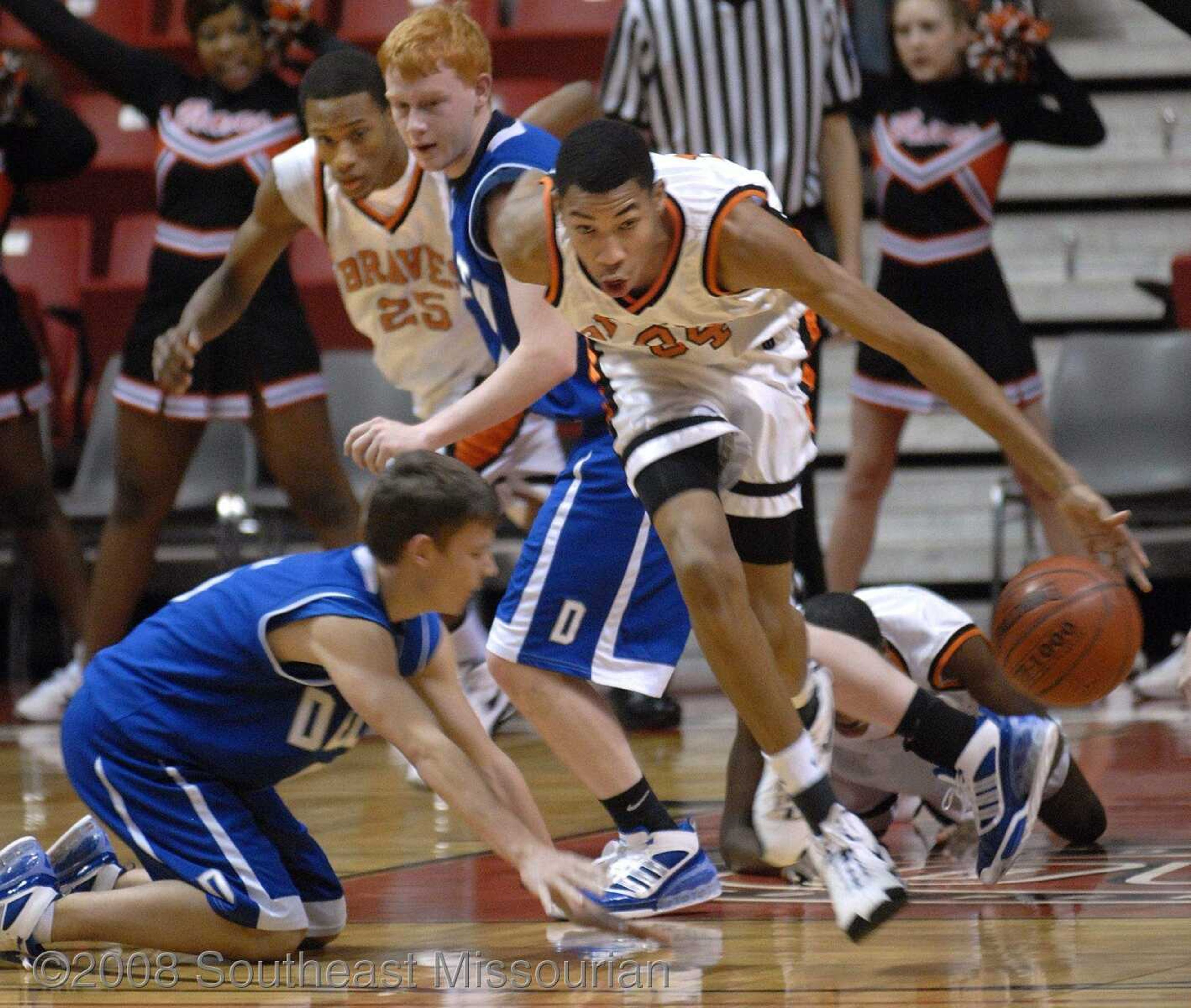 FRED LYNCH ~ flynch@semissourian.com
Scott County Central's Otto Porter scoops up the ball and drives away from Delta's Cody Helderman, left, and Shelby Kight in the first quarter of their first-round game in the Southeast Missourian Christmas Tournament Friday at the Show Me Center.