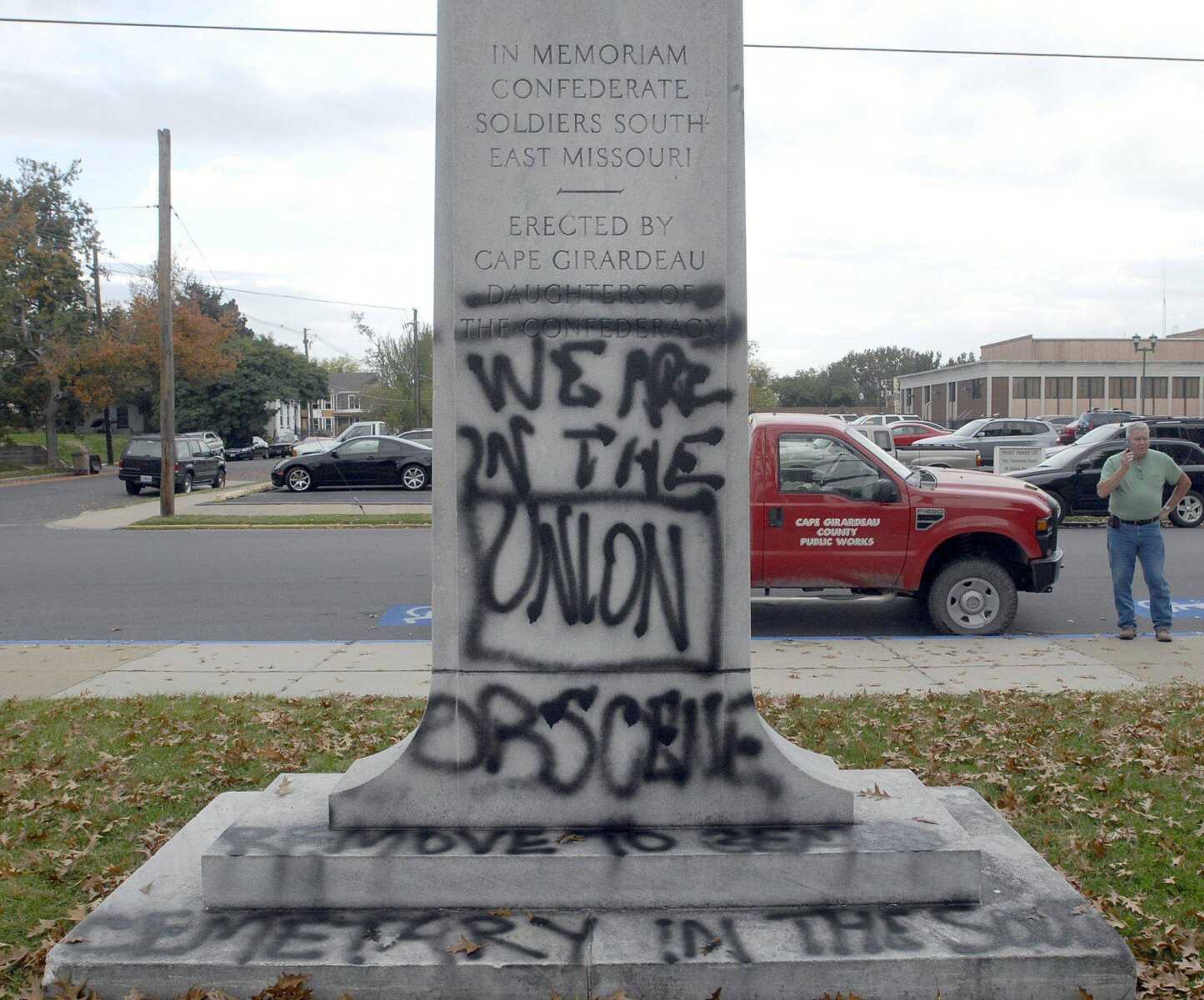 Cape Girardeau County public works director Don McQuay makes a phone call to Liley Monument Works Tuesday morning after vandals spray painted graffiti on the Civil War monument in the courtyard of the Common Pleas Courthouse in Cape Girardeau. The removal of the graffiti will cost between four and six hundred dollars. (Laura Simon)