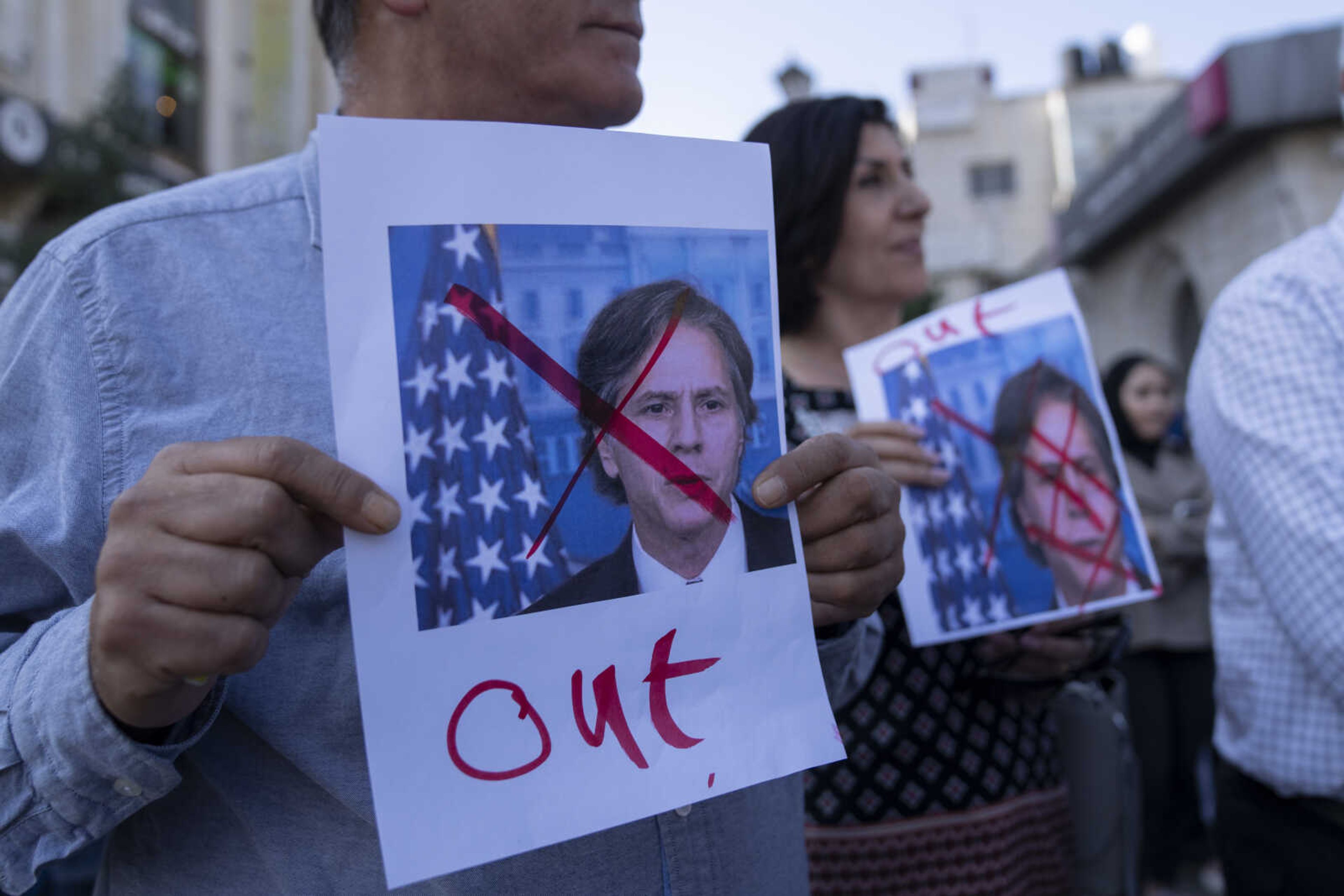 Palestinians carry posters with defaced pictures of U.S. Secretary of State Antony Blinken during a protest against his visit Sunday in the West Bank city of Ramallah.