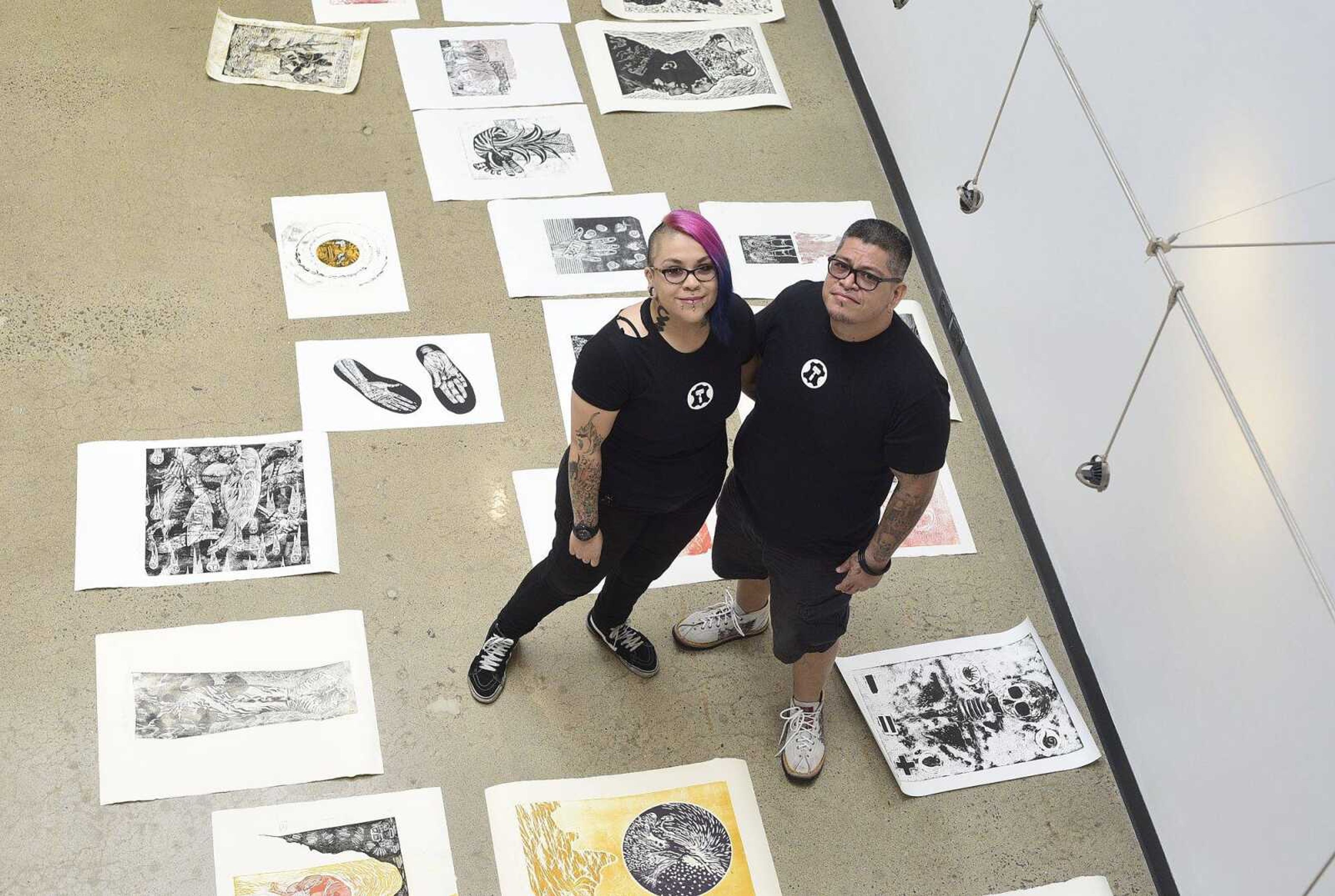 Alejandra Mares, left, and her husband, Xavier Moreno, pose for a photo before hanging artwork for an upcoming show at Catapult Creative House in Cape Girardeau.