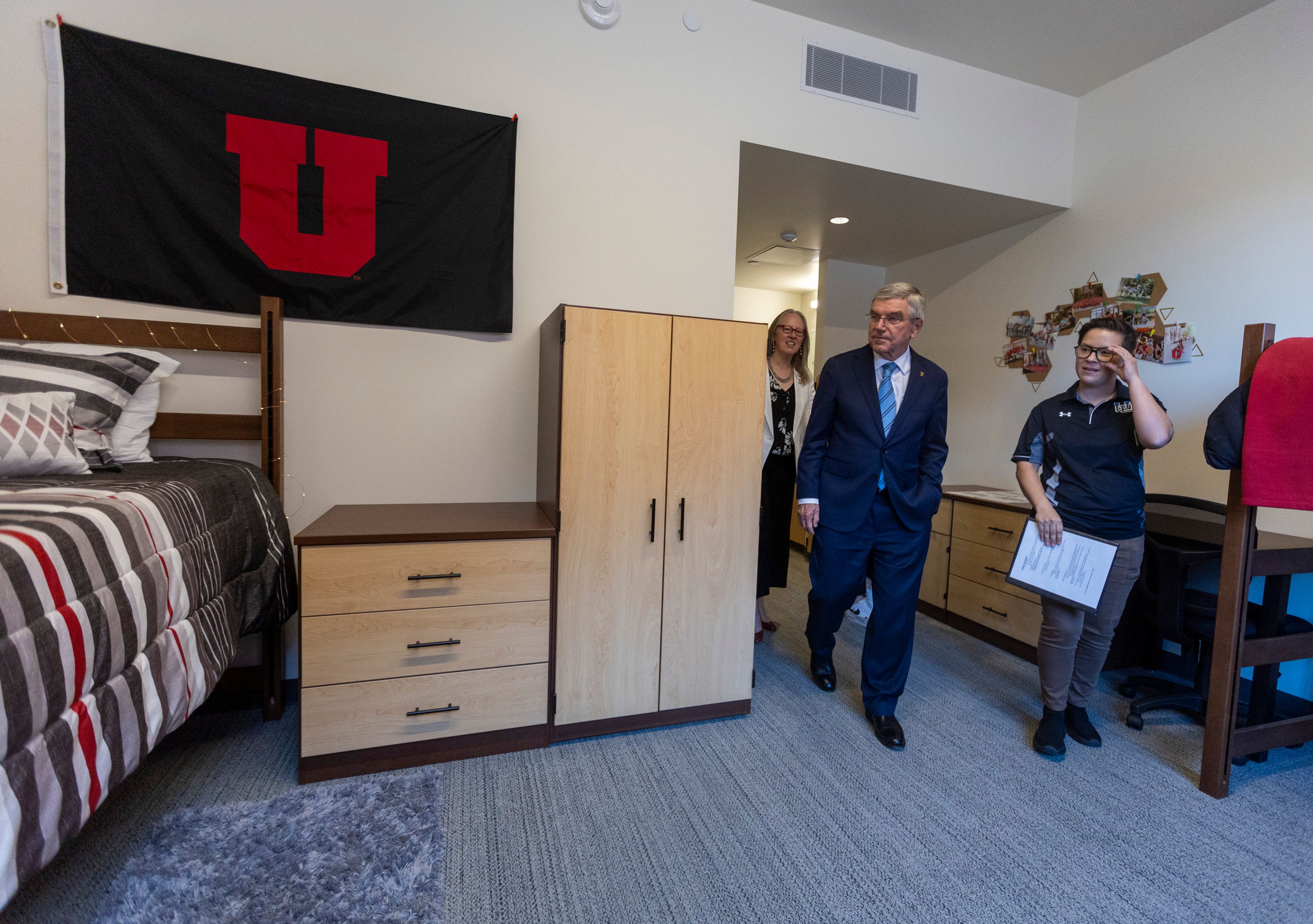 Rachel Aho, senior director of housing operations for the University of Utah, right, gives International Olympic Committee President Thomas Bach, center, a tour of housing in Kahlert Village as he leads a delegation visiting ahead of the 2034 Winter Olympics, at University of Utah in Salt Lake City on Friday, Sept. 27, 2024. (Brice Tucker/The Deseret News via AP)