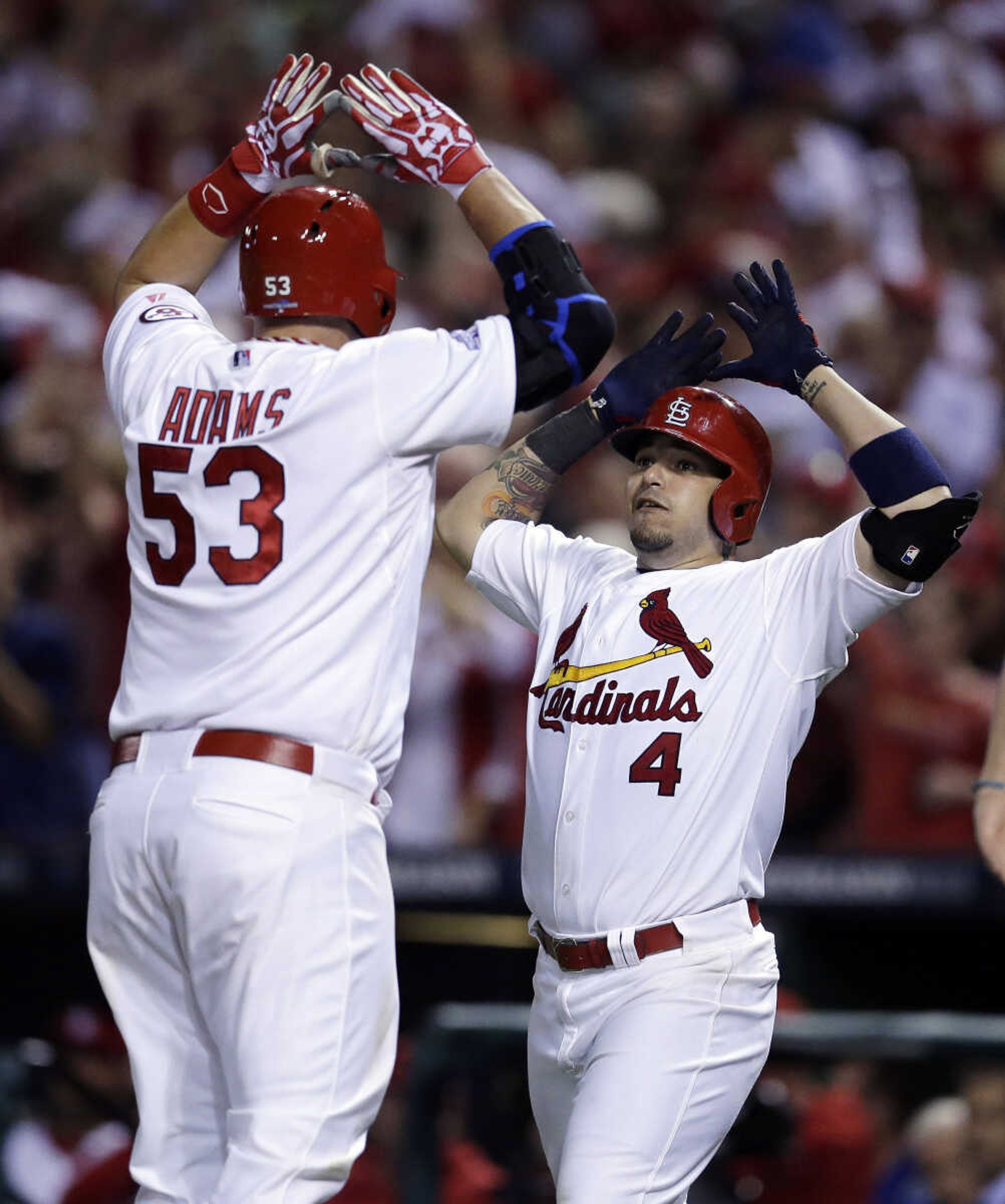 St. Louis Cardinals' Matt Adams (53) celebrates with Yadier Molina (4) as Adams crosses home plate after hitting a two-run home run against the Pittsburgh Pirates in the eighth inning in Game 5 of a National League baseball division series on Wednesday, Oct. 9, 2013, in St. Louis. The Cardinals won the game 6-1and won the series 3 games to 2.(AP Photo/Charlie Riedel)