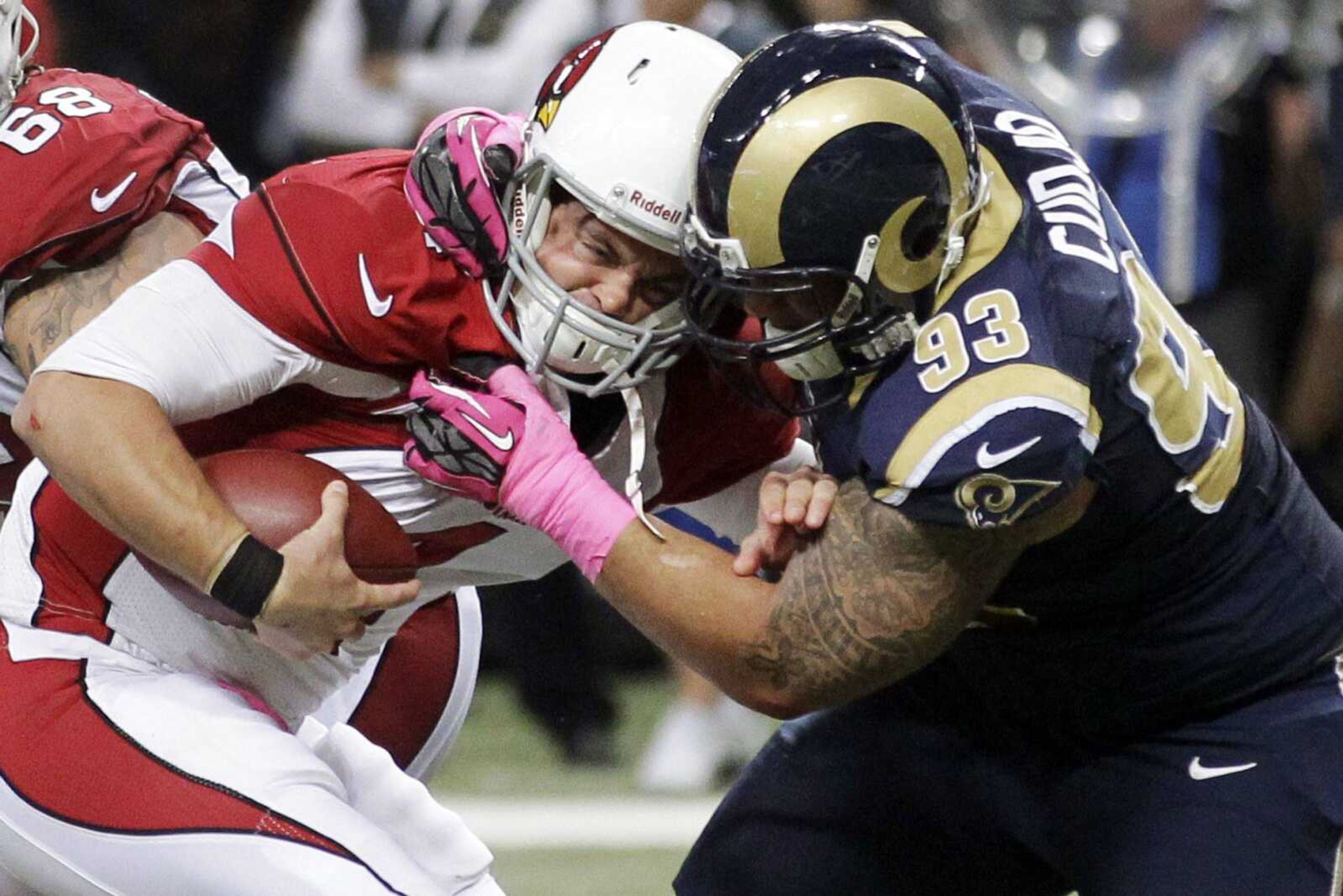 Arizona Cardinals quarterback Kevin Kolb, left, is sacked by St. Louis Rams defensive tackle Jermelle Cudjo during the third quarter of an NFL football game, Thursday, Oct. 4, 2012, in St. Louis. Cudjo was charged with an unnecessary roughness penalty on the play. (AP Photo/Seth Perlman)