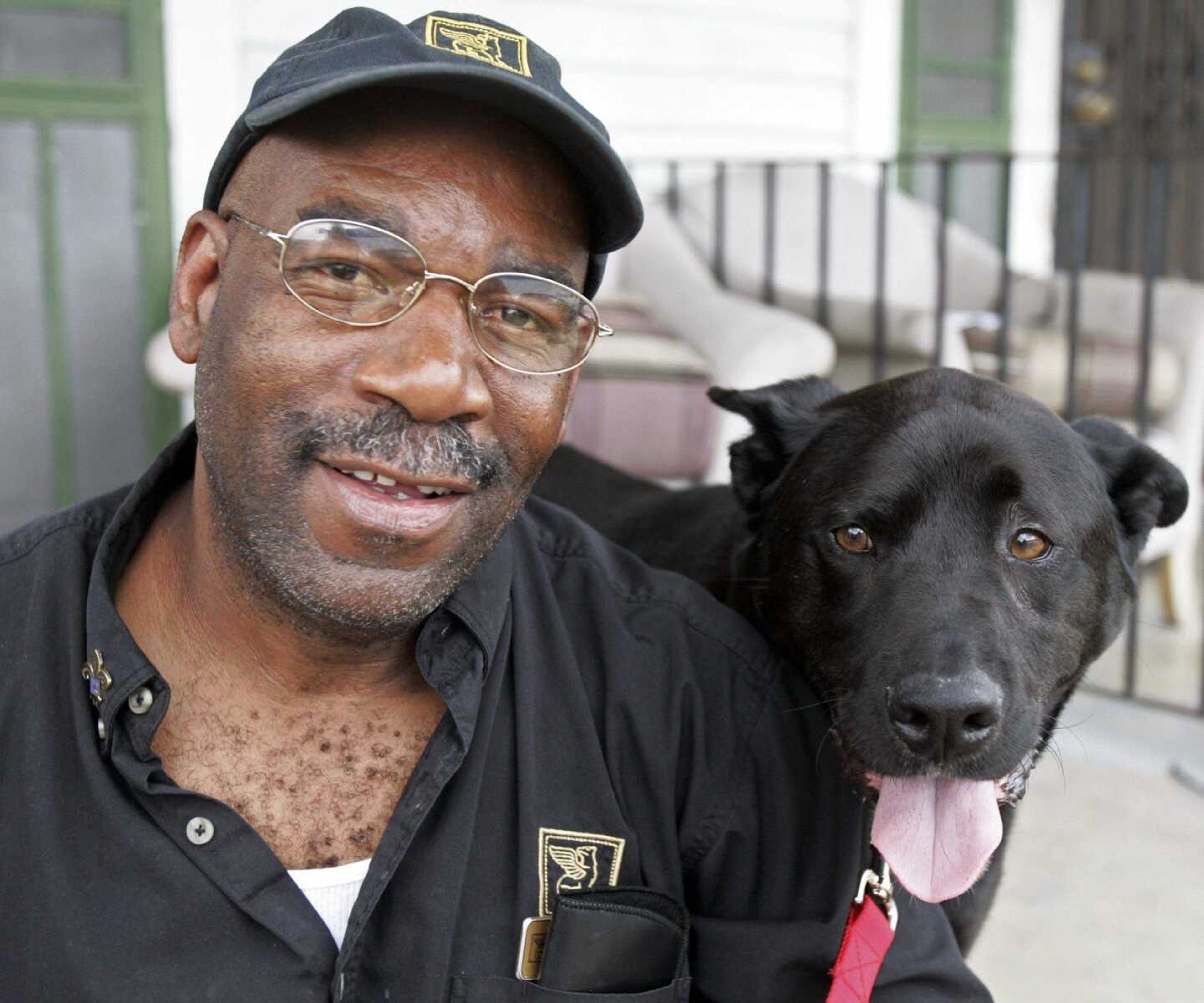 Jessie Pullins and his dog J.J. posing for a photograph on the steps of their home in New Orleans. Pullins was reunited with J.J. after almost four-year separation because of Hurricane Katrina. His fight to be reunited with his pet is portrayed in "Mine," a documentary that won an audience award at the South by Southwest film festival. (Bill Haber ~ Associated Press)