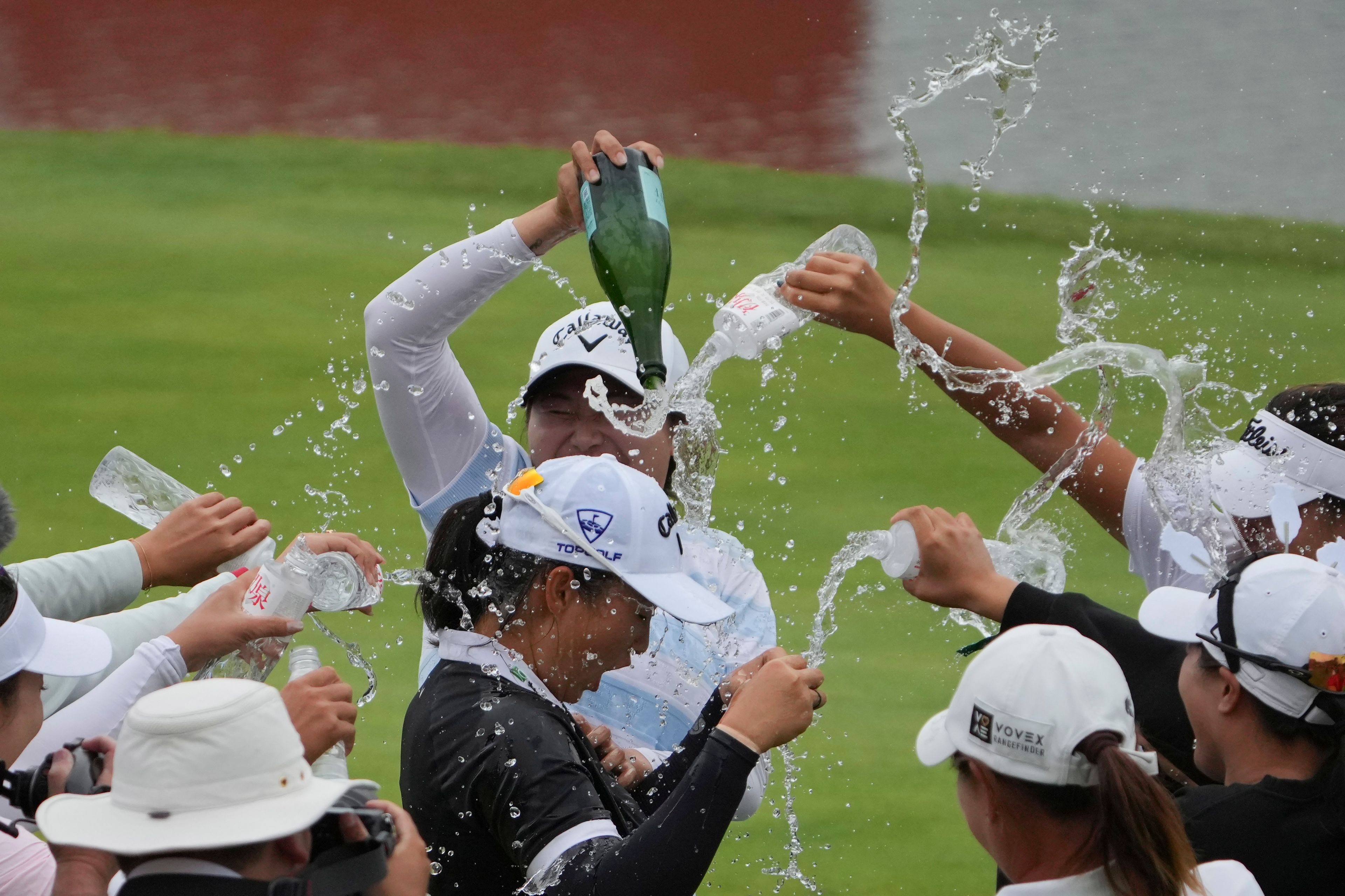 Fellow golfers sprinkle water on Ruoning Yin of China after she wins the final round of the LPGA Shanghai at China's Shanghai Qizhong Garden Golf Club, Sunday, Oct. 13, 2024. (AP Photo/Achmad Ibrahim)