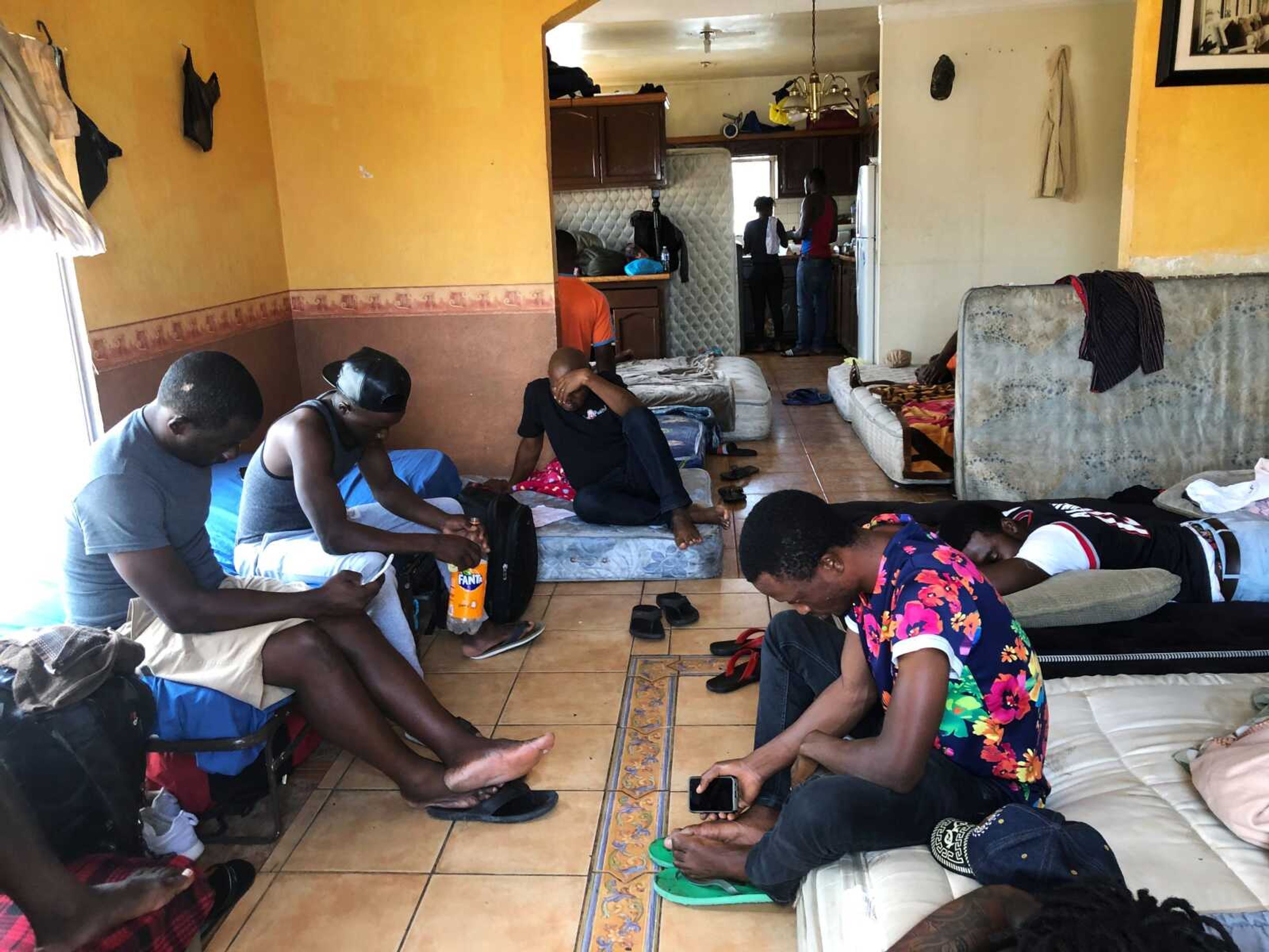 FILE - In this July 28, 2019, file photo, Cameroonians wait in a rented apartment in Tijuana, Mexico, until their names are called to claim asylum in the U.S.  President Donald Trump isn t the only world leader making it virtually impossible for many Africans to get asylum in the United States.  Ecuador is closing its doors as one of the few countries in North and South America to welcome African visitors, depriving them of a starting point for their dangerous journeys north by land.  (AP Photo/Elliot Spagat, File)