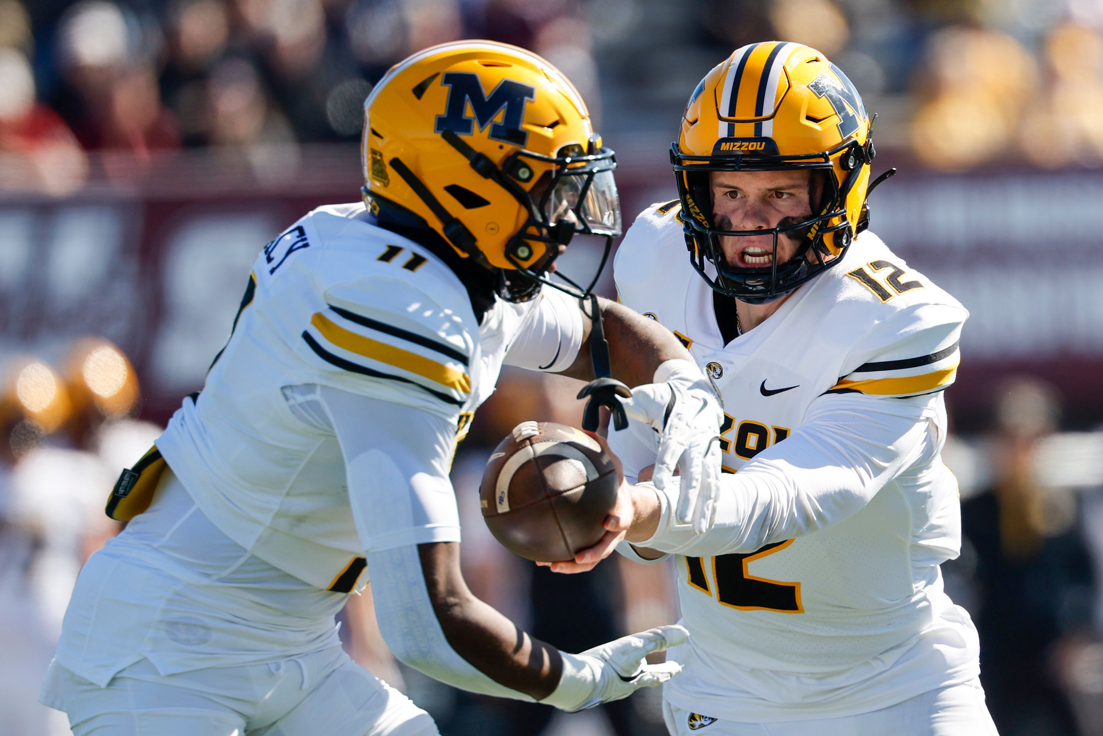 Missouri quarterback Brady Cook (12) hands the ball off to running back Kewan Lacy (11) during the first half of an NCAA football game against Massachusetts, Saturday, Oct. 12, 2024, in Amherst, Mass. (AP Photo/Greg M. Cooper)