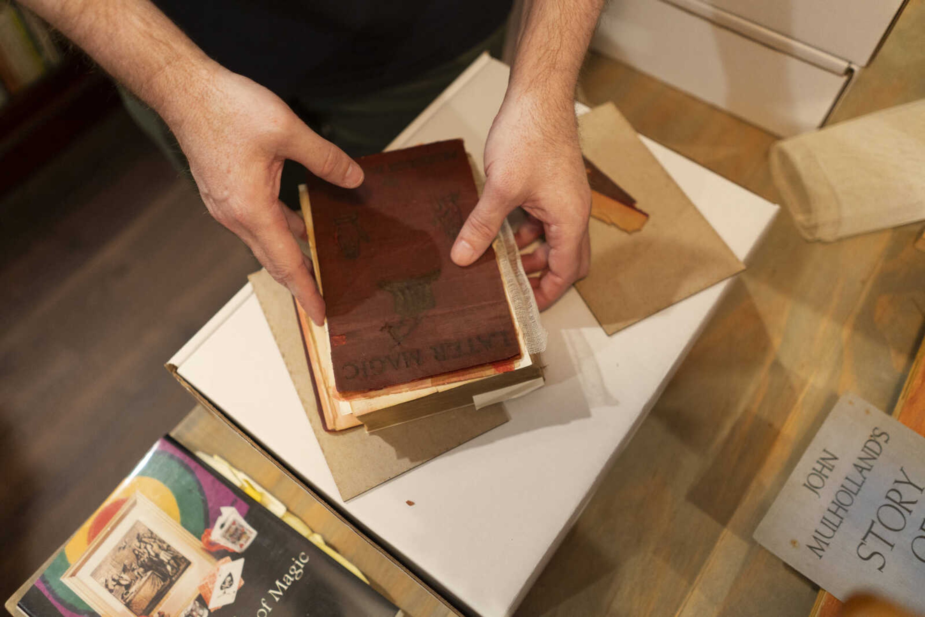 Gary Howard, Jr. shows a book that he will soon restore for a client. Howard says people get books restored either for love or for money.