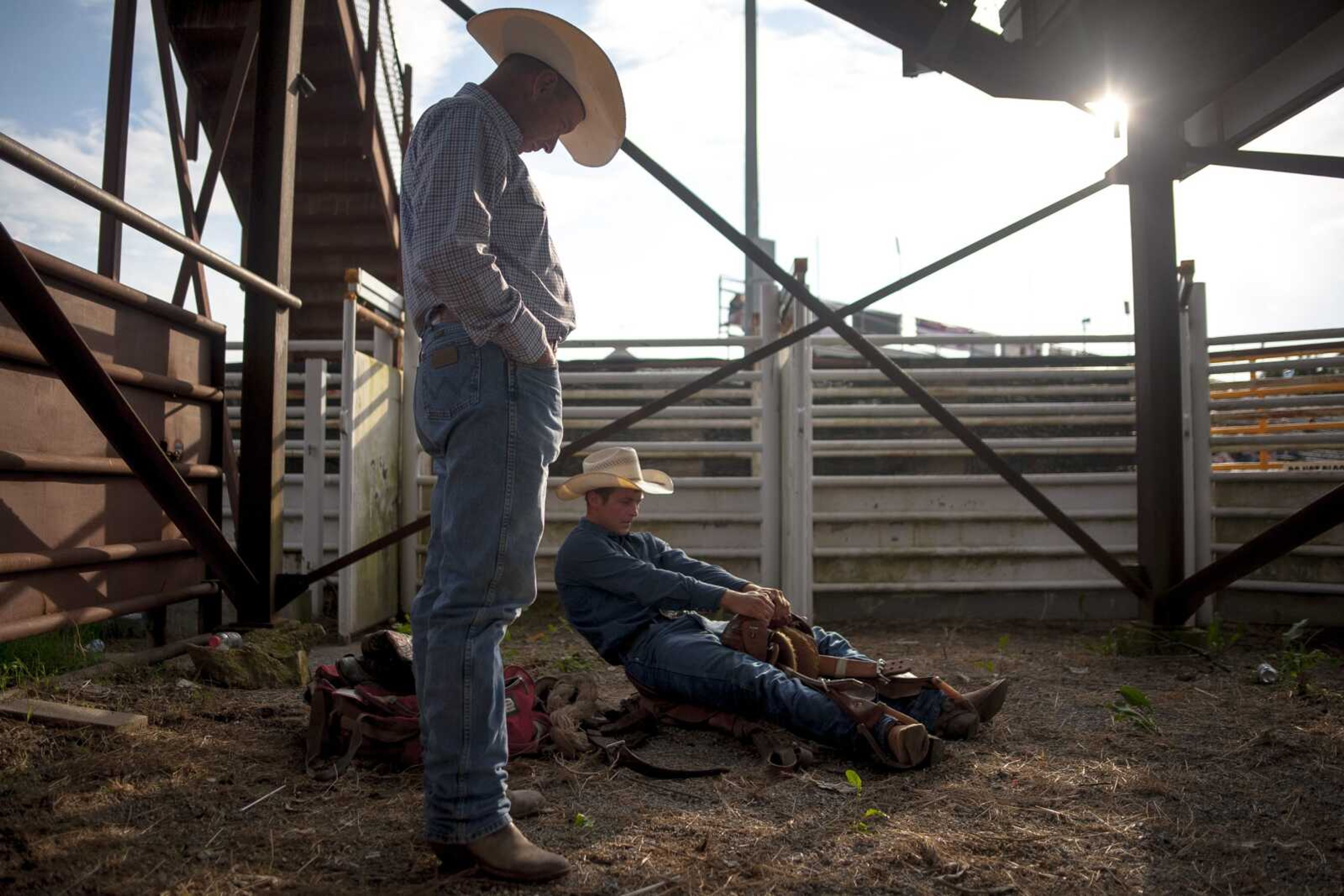 Chance Masters, right, tests his saddle during the Sikeston Jaycee Bootheel Rodeo Wednesday, Aug. 7, 2019, in Sikeston.