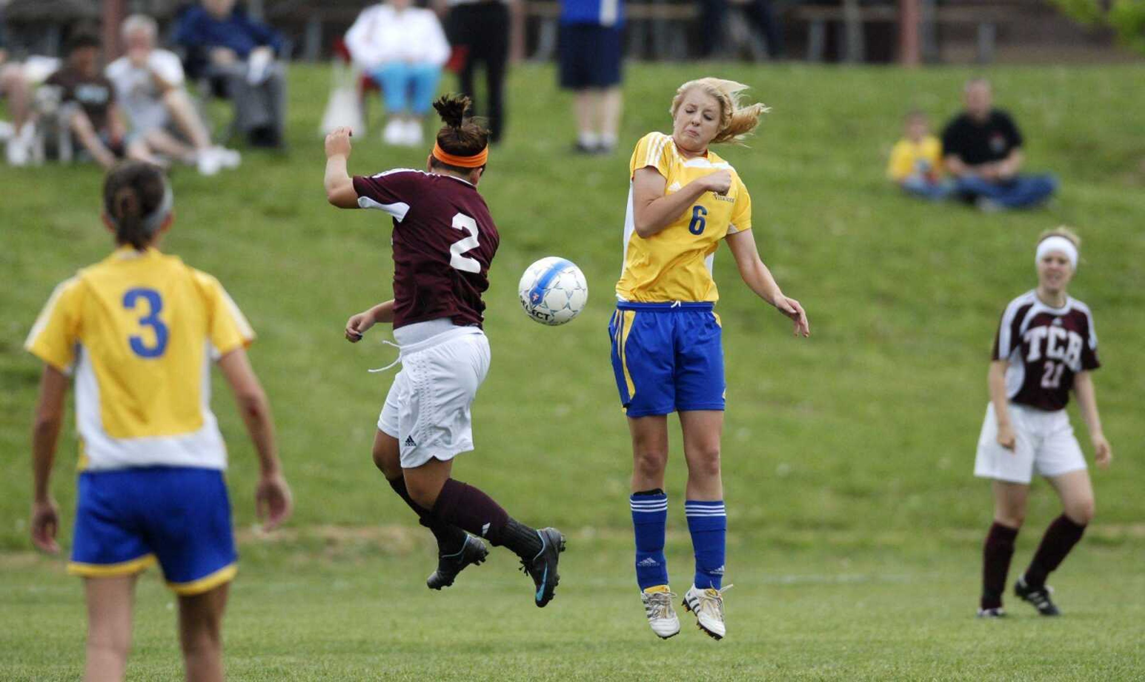 Trinity Catholic's Abby Whittington and St. Vincent's Courtney Heberlie jump for a free ball during the first half of their game Friday in Perryville, Mo. (KRISTIN EBERTS)