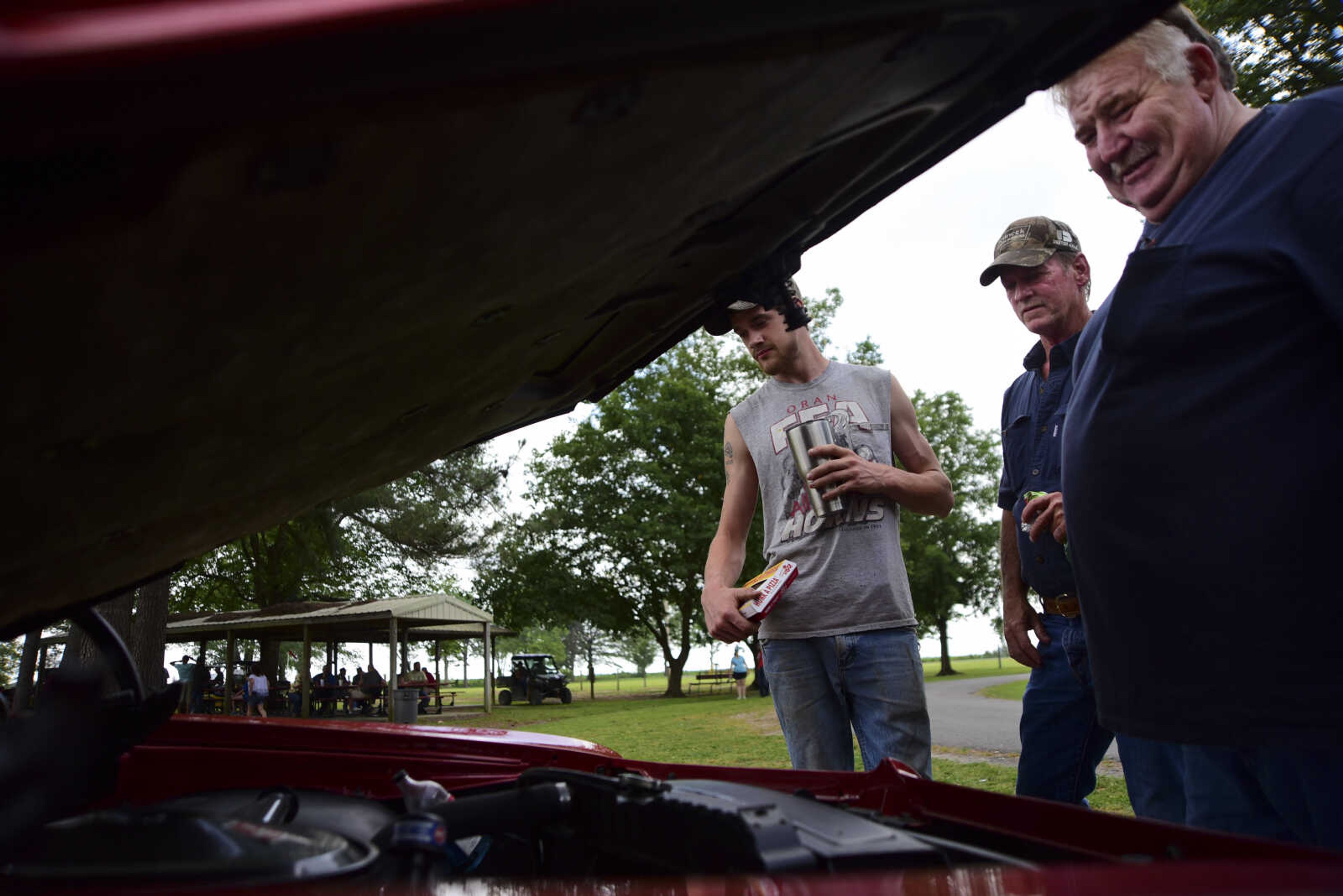 Patrick Markham, Kenny Pinkerton and Randy Allen look at vehicles during the 22nd annual Oran Car Show at George Tilles Jr. Memorial Park Saturday, June 3, 2017 in Oran.