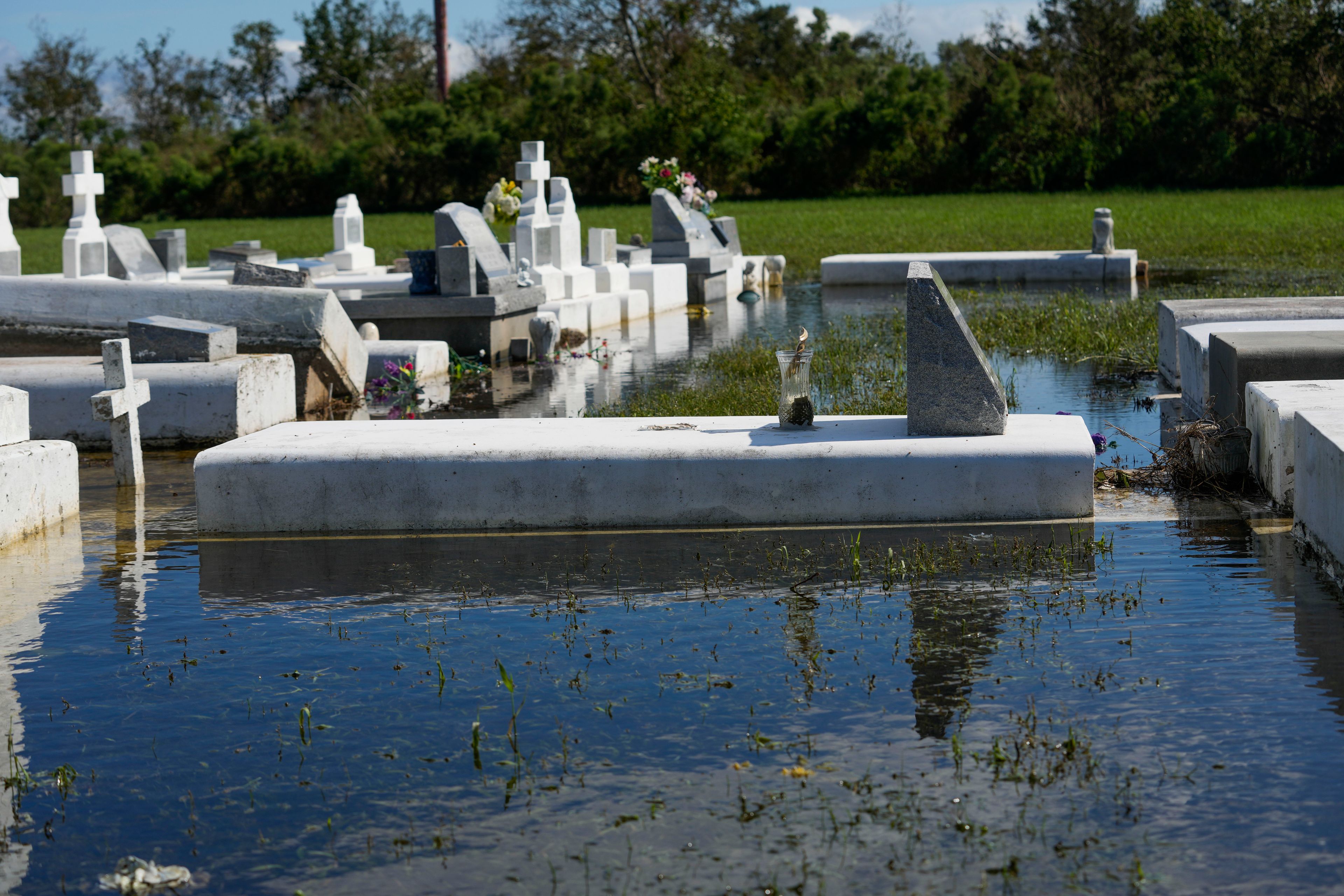 Tombs are seen after being disturbed by flooding, in the aftermath of Hurricane Francine, in Dulac, La., Thursday, Sept. 12, 2024. (AP Photo/Gerald Herbert)