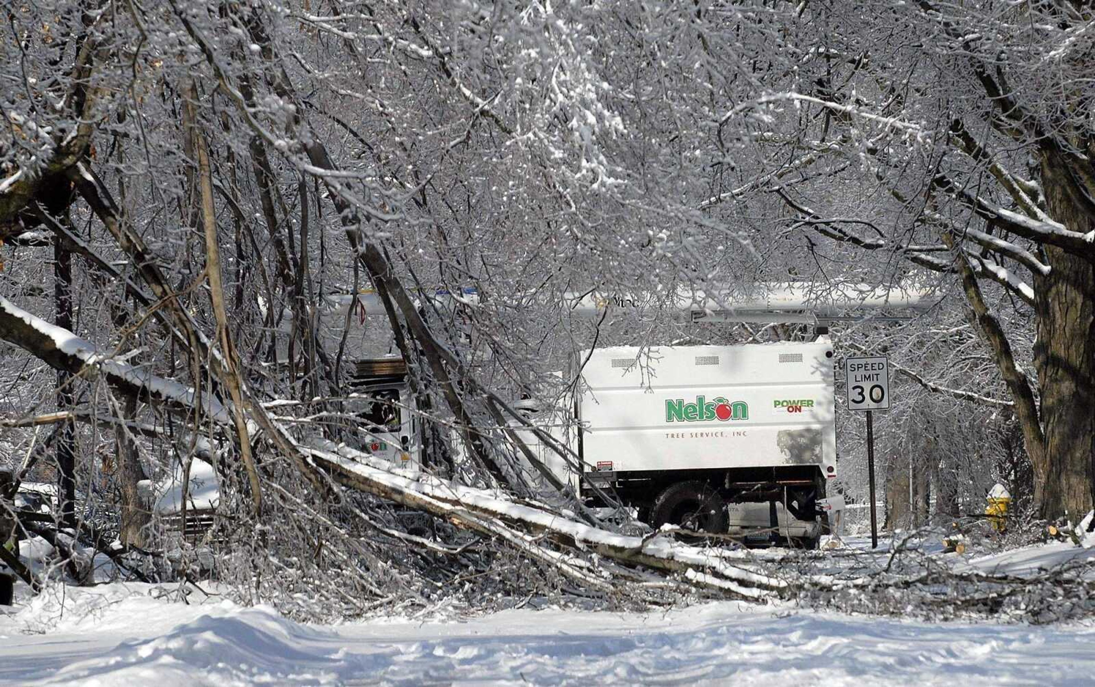 ELIZABETH DODD ~ edodd@semissourian.com<br>Nelson Tree Service trucks make their way around a Cape Girardeau neighborhood without power near South Sprigg Street Wednesday.