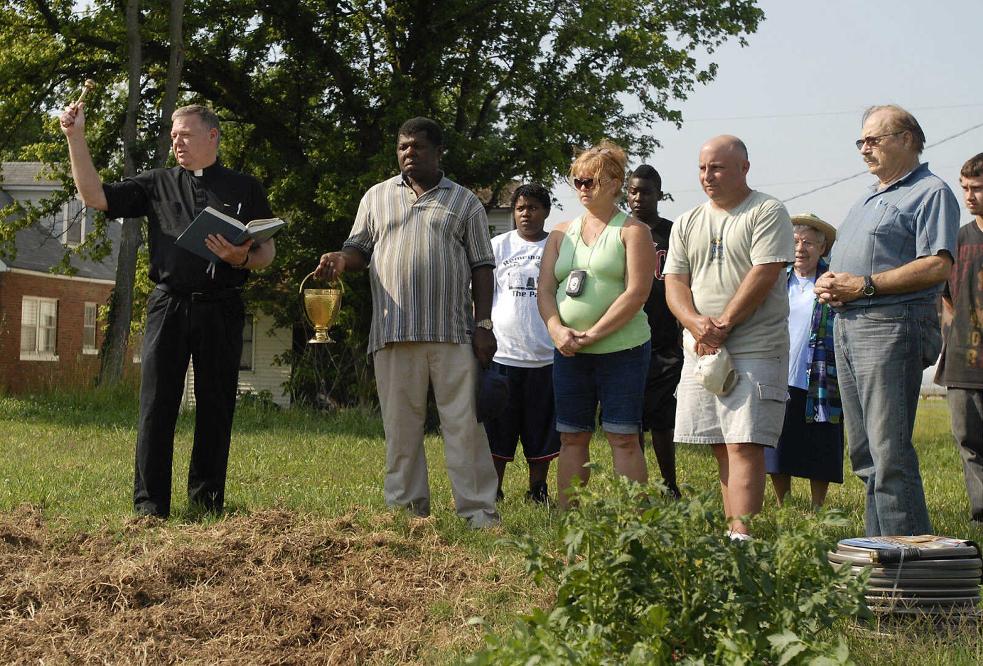 KRISTIN EBERTS ~ keberts@semissourian.com

Father Tom Kiefer, left, of St. Mary Cathedral, says a blessing before volunteers start planting vegetables on Friday, June 10, 2011, in the new garden off South Sprigg Street in Cape Girardeau that will be used to supplement the Catholic Ministry Pantry's food supply.