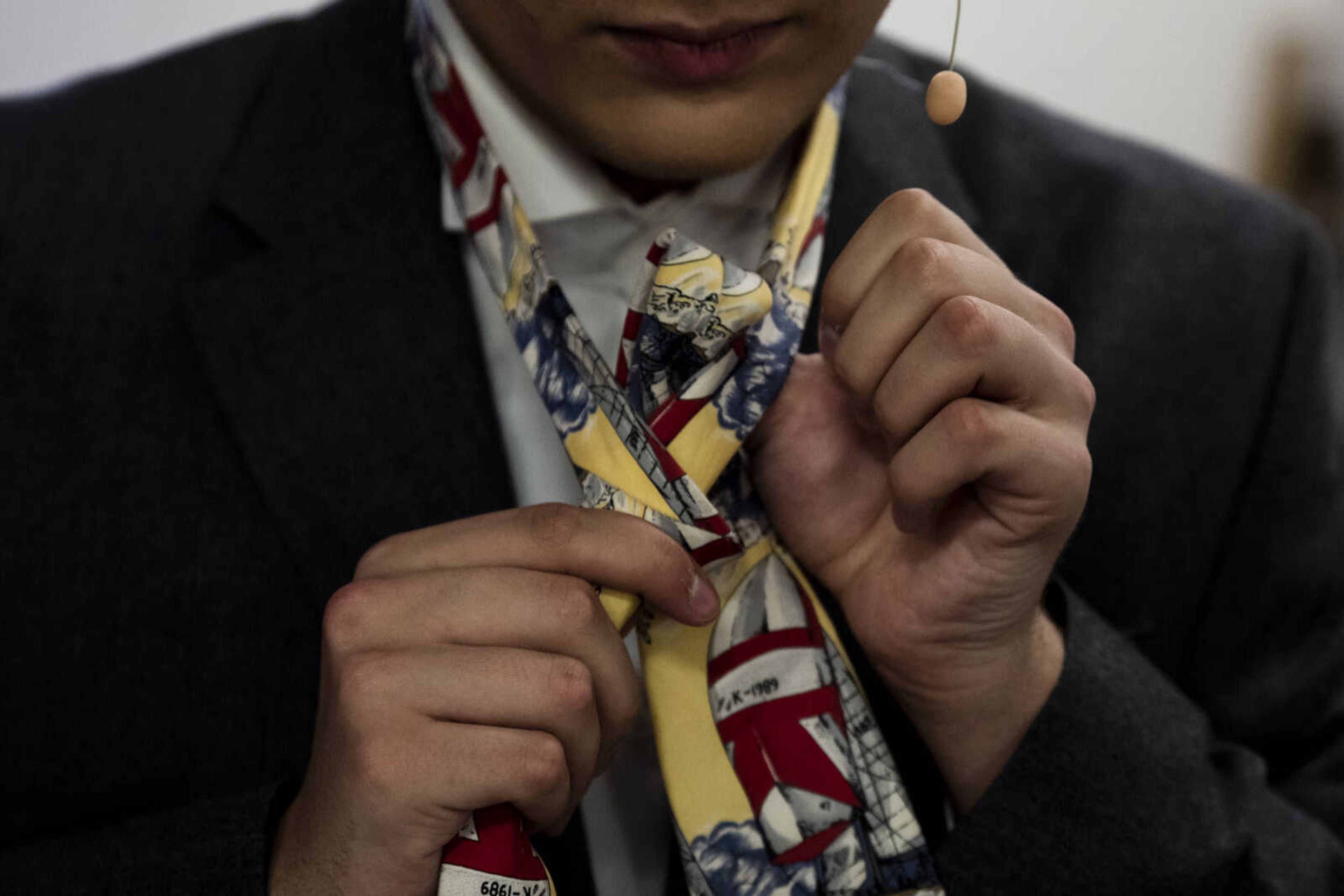 Tyler Helm, 17, ties a tie to complete his character, Harry Bright's, look during the media night of Cape Central High School's spring musical production of "Mamma Mia!" Wednesday, April 10, 2019, in Cape Girardeau.